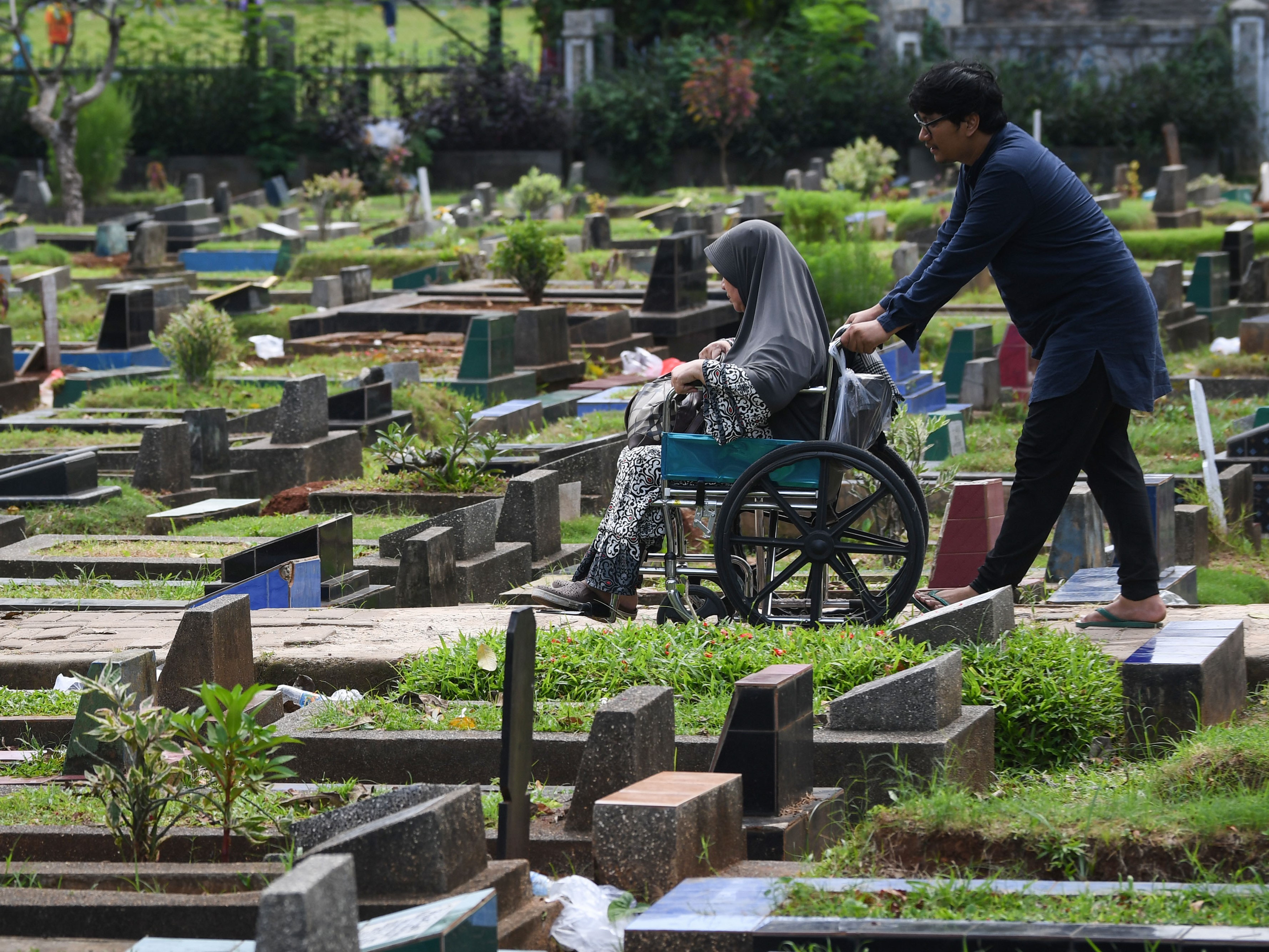 Dua warga berziarah di makam keluarganya di Tempat Pemakaman Umum (TPU) Karet Kebembem, Tanah Abang, Jakarta, Minggu (19/3/2023).