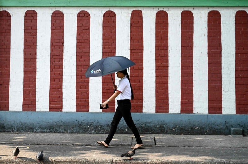 Warga melindungi diri dari sinar matahari di cuaca panas ekstrem.