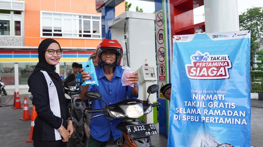 Seorang warga yang tengah mengisi BBM mendapatkan takjil dari Pertamina