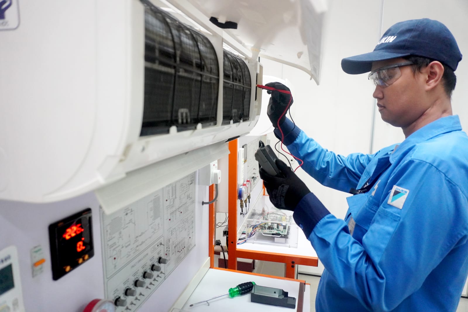 Ilustrasi teknisi Daikin memperbaiki produk elektronik