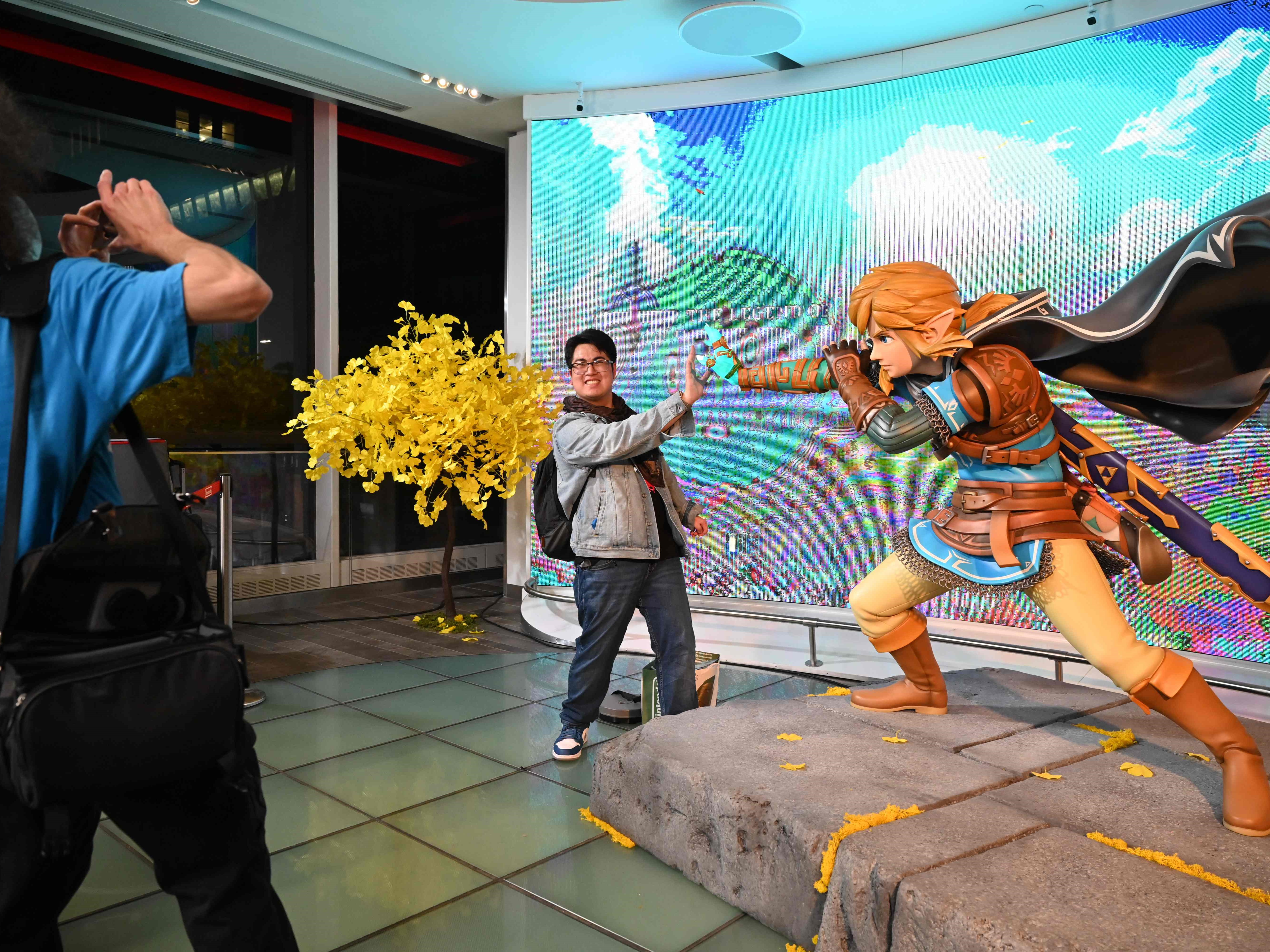 Konsumen berfoto dengan Link, karakter dalam Zelda setelah membeli The Legend of Zelda: Tears of the Kingdom.
