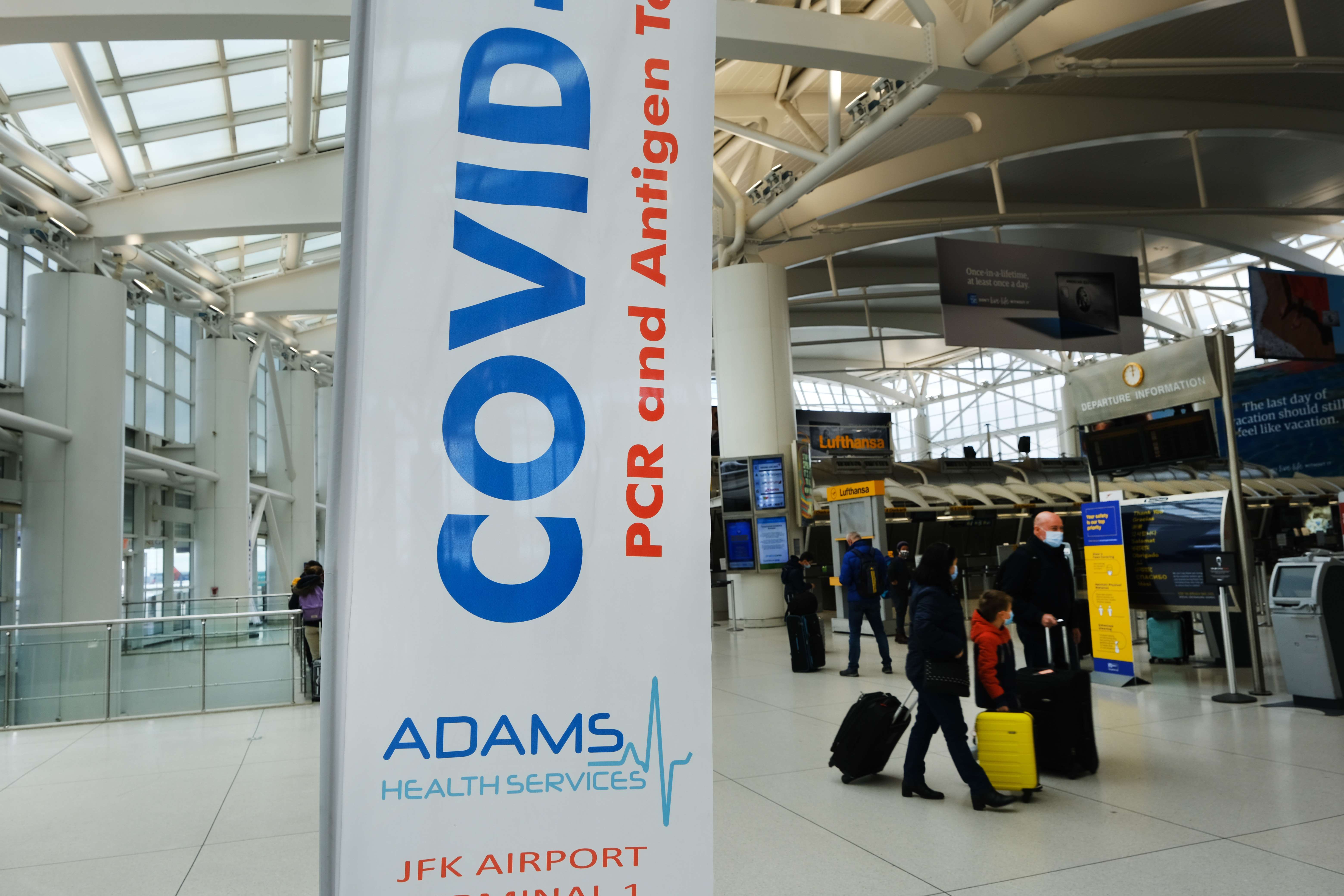 Pelancong mengenakan masker saat berada di Bandara JFK, New York, Amerika Serikat. 