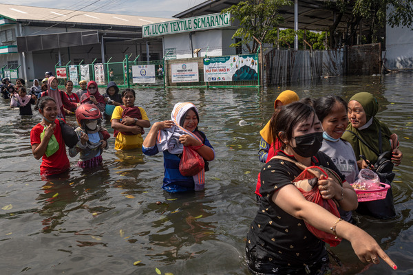 Karyawan pabrik menerjang banjir rob di kawasan industri Tanjung Emas, Semarang.