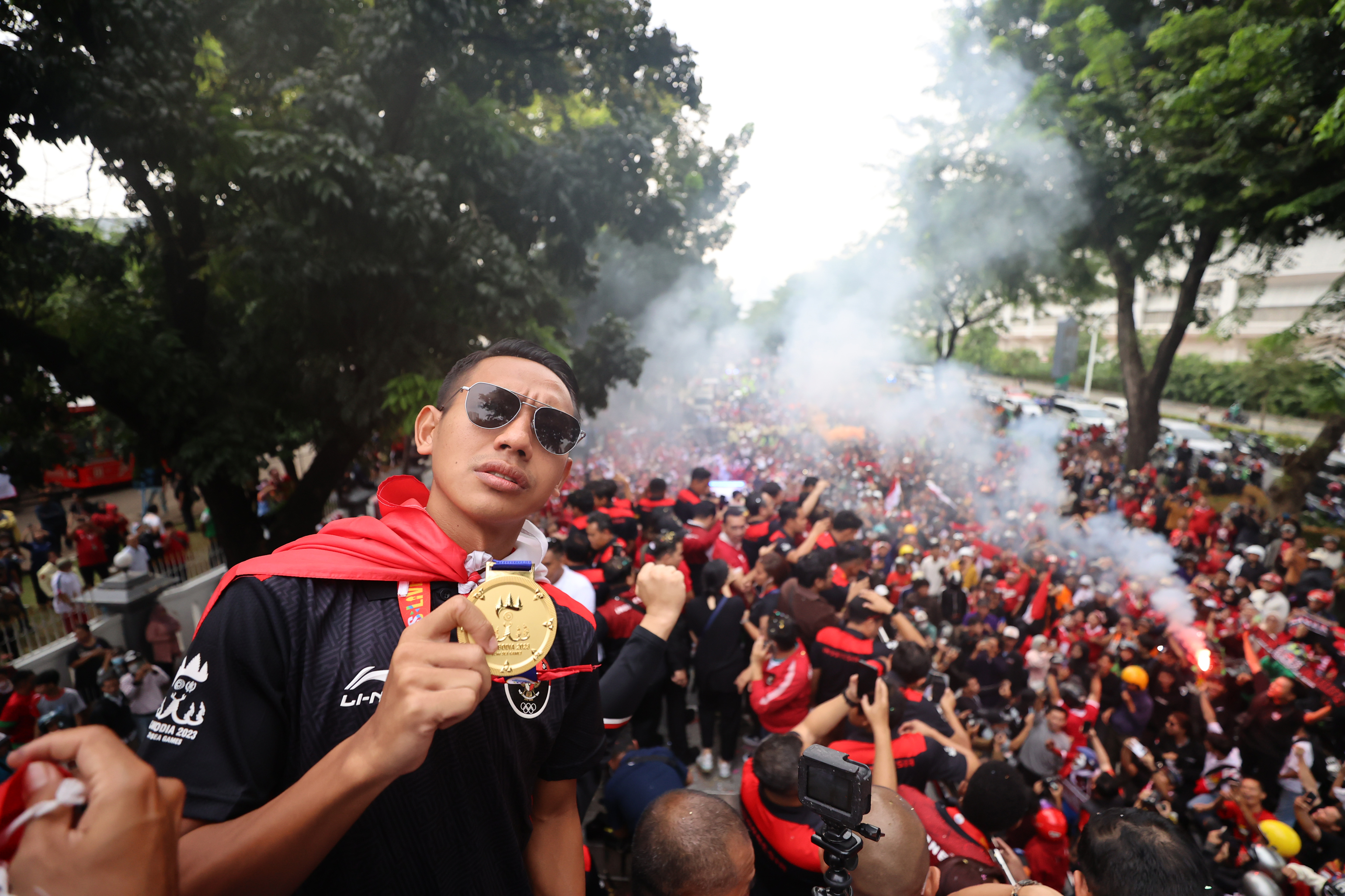  Pesepak bola tim U-22 Indonesia Beckham Putra melakukan selebrasi di atas bus Transjakarta dalam arak-arakan Kontingen SEA Games