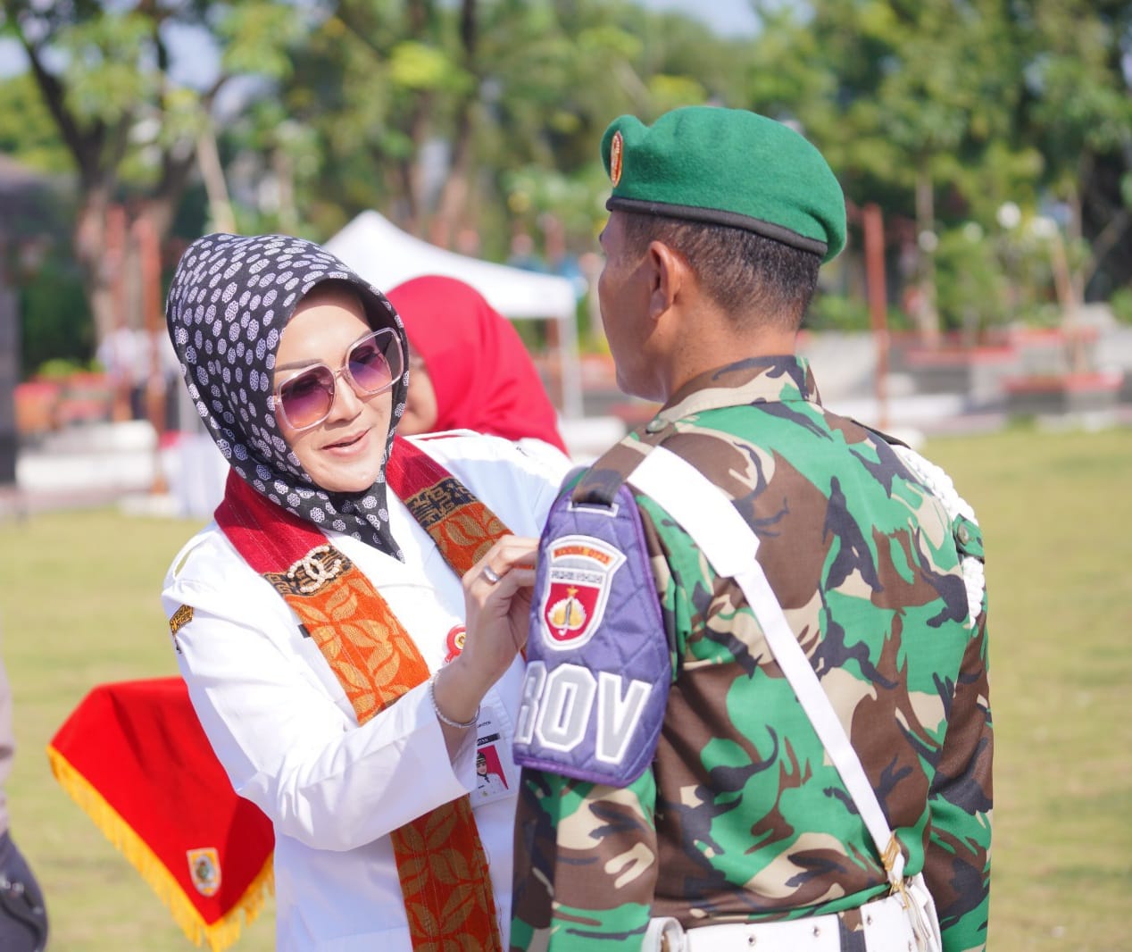 Bupati Sri Mulyani memasang pita pada perwakilan pasukan pengamanan pilkades. 