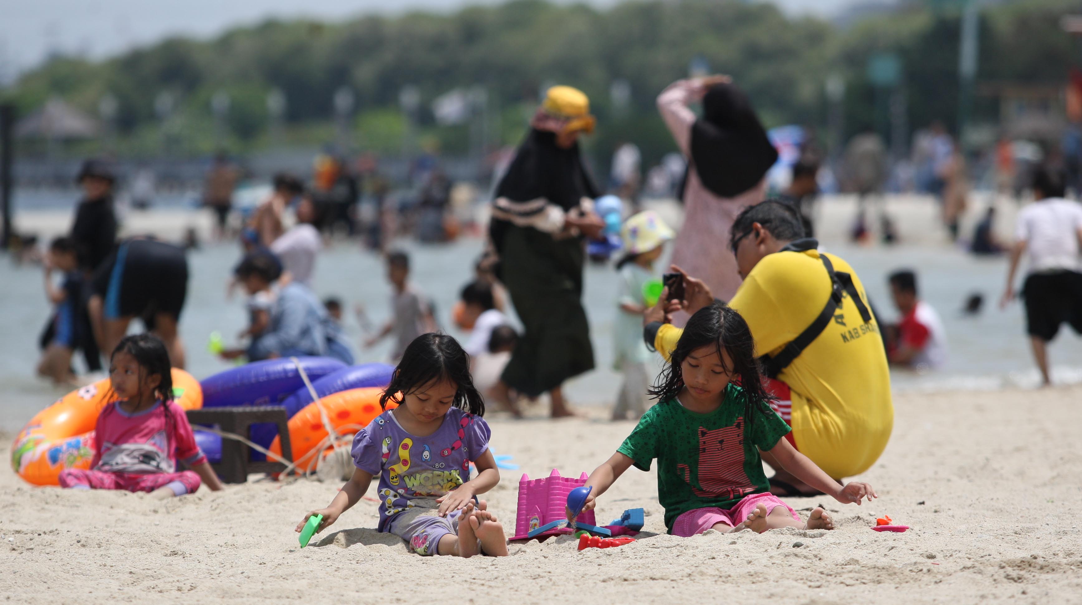  Pengunjung yang didominasi anak-anak bermain di Pantai Lagoon, Ancol, Jakarta