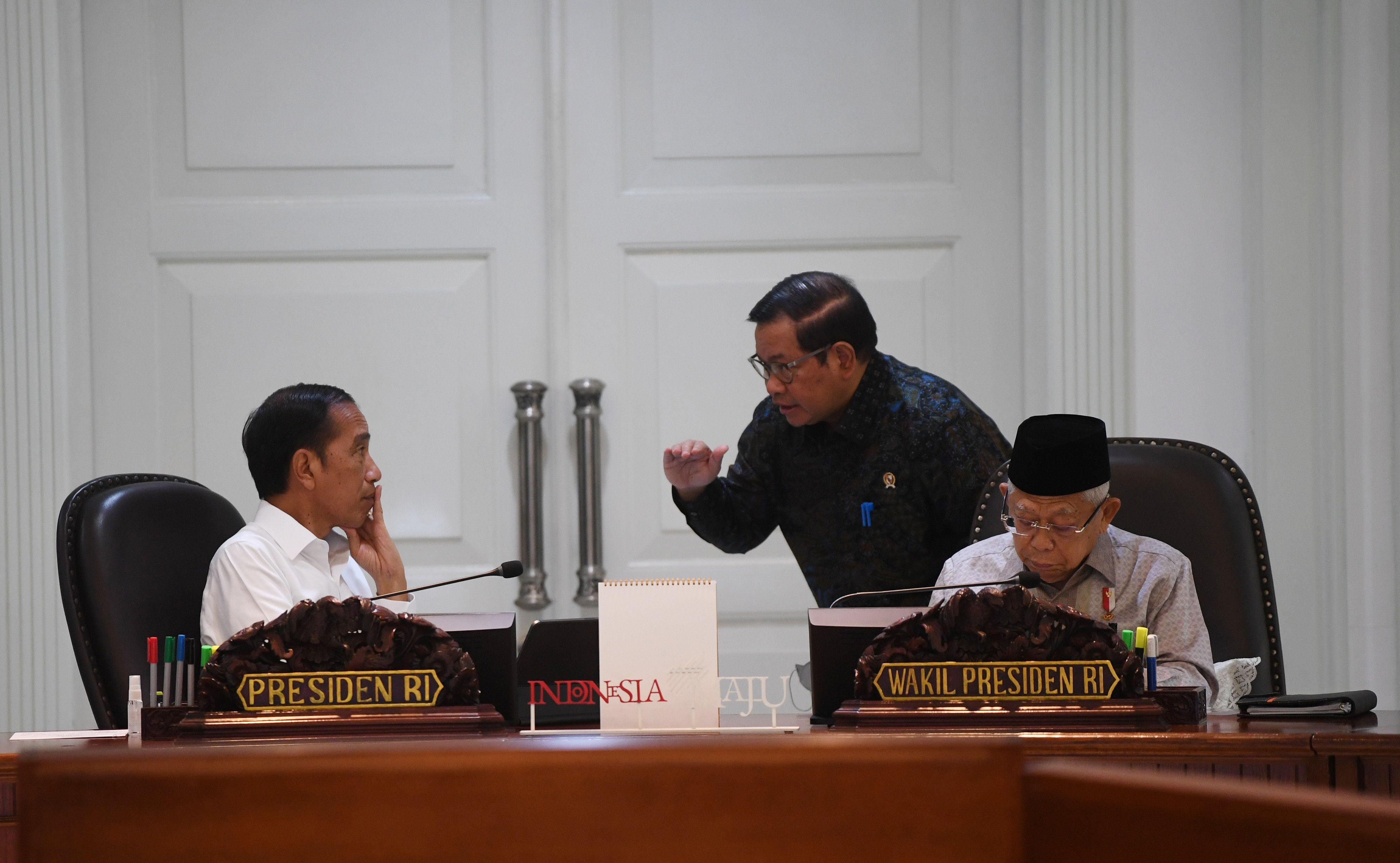 Presiden Joko Widodo (kiri) bersama Wakil Presiden Ma'ruf Amin (kanan) berbincang dengan Seskab Pramono Anung (tengah) 