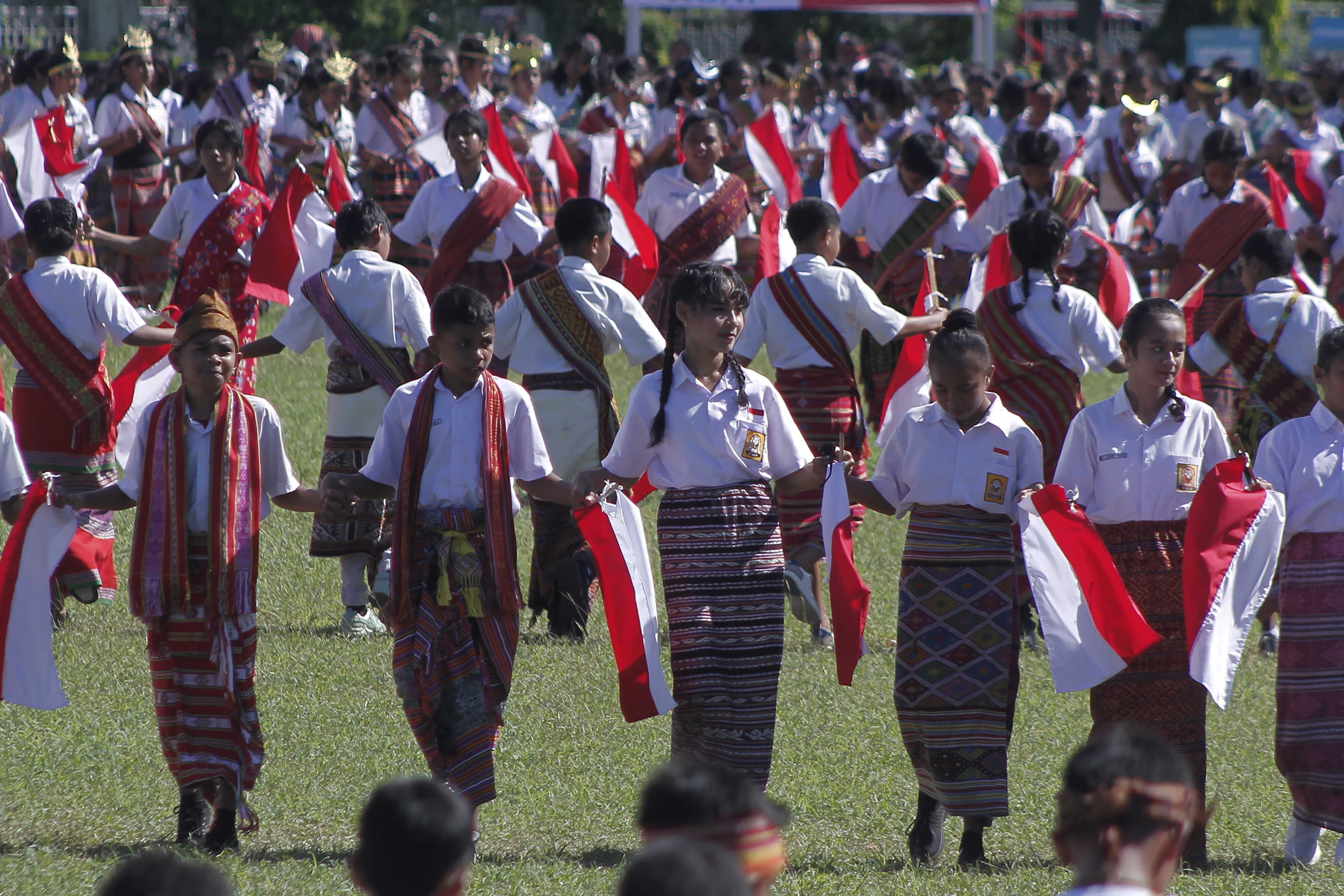 Sejumlah pelajar berpakaian adat Timor mengibarkan bendera merah putih saat menampilkan tarian Lufut di Kota Kupang, NT, Jumat (28/4).