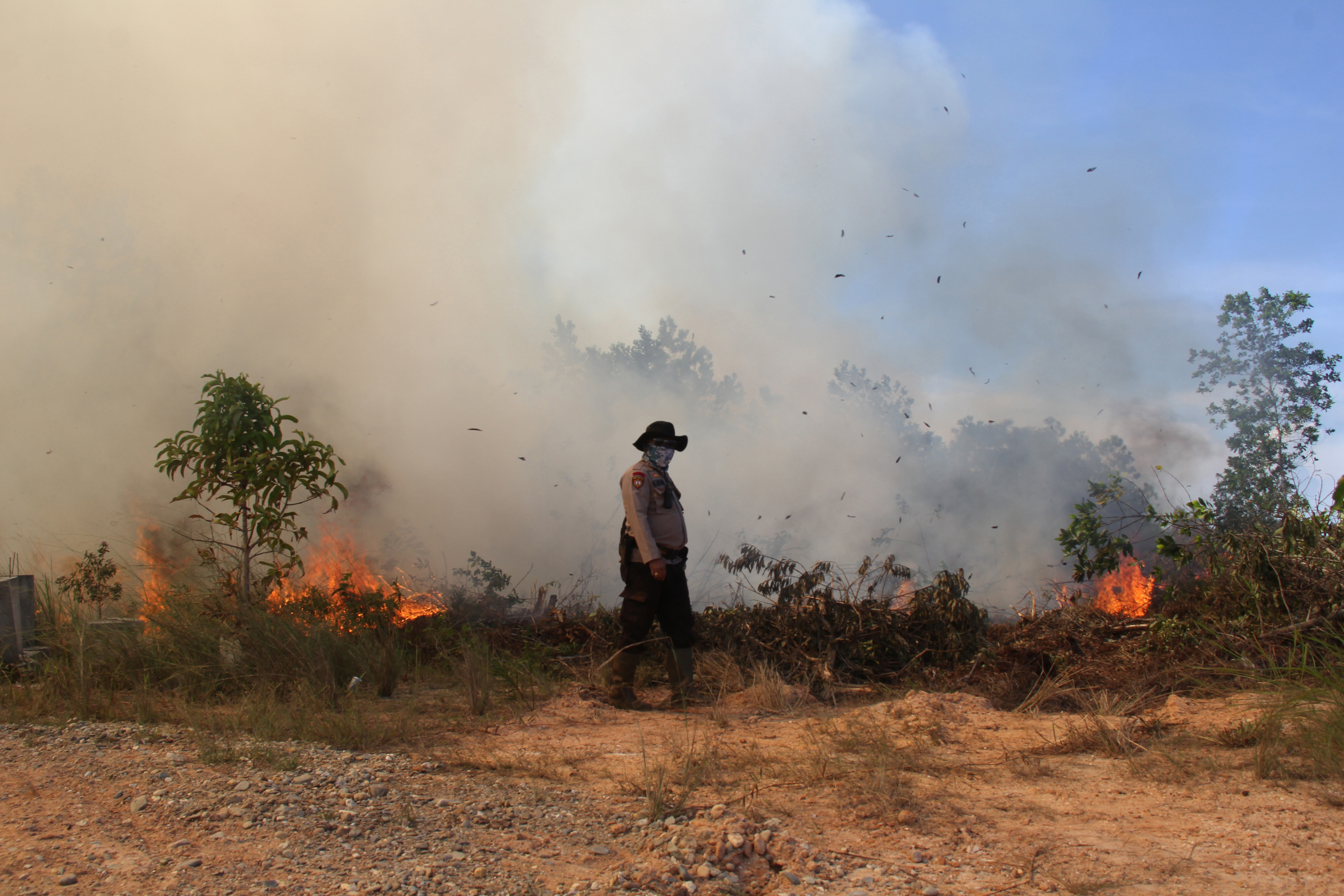 Petugas kepolisian berada di sekitar lahan yang terbakar di Desa Pelintung Kecamatan Medang Kampai Dumai, Riau, Selasa (2/5).