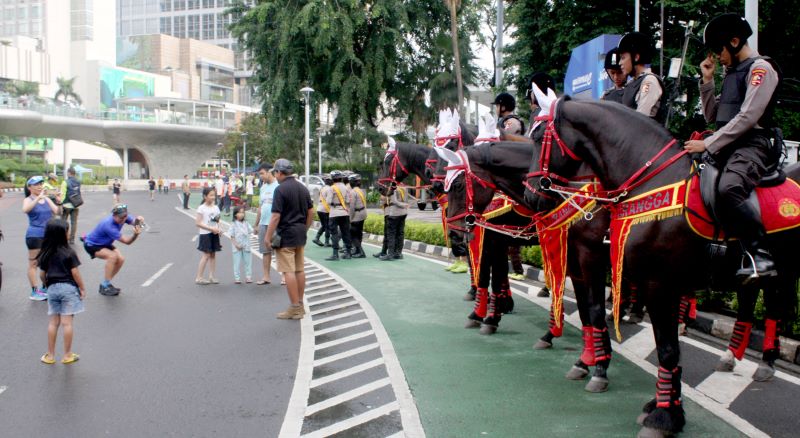 Petugas Polisi Patroli Berkuda dan Sepedah berjaga-jaga saat masyarakat melakukan aktifitas berolahraga pada car free day di Jakarta.
