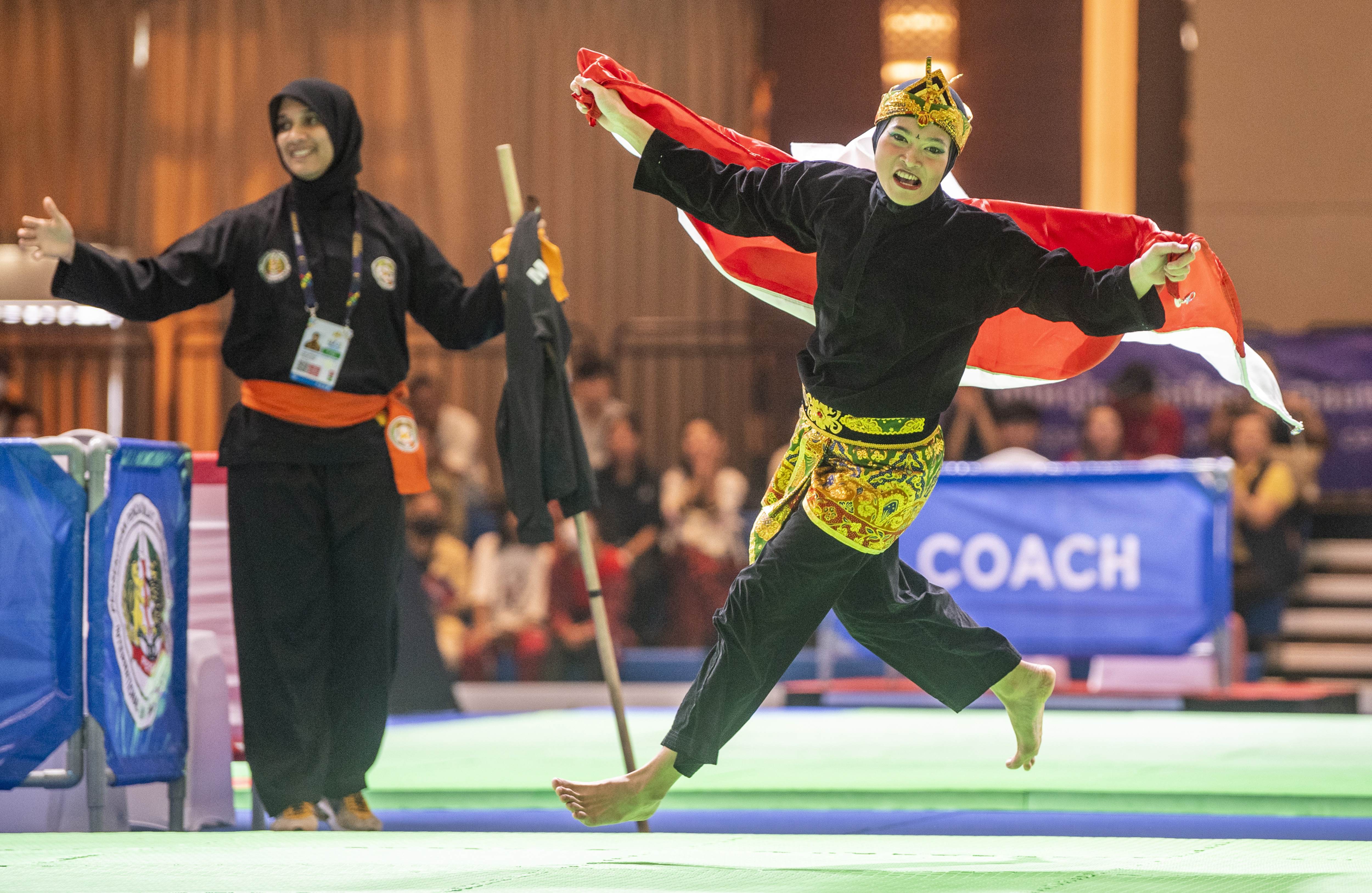 Pesilat putri Indonesia Puspa Arum Sari mengibarkan bendera Merah Putih seusai final nomor seni tunggal putri saat SEA Games 2023.