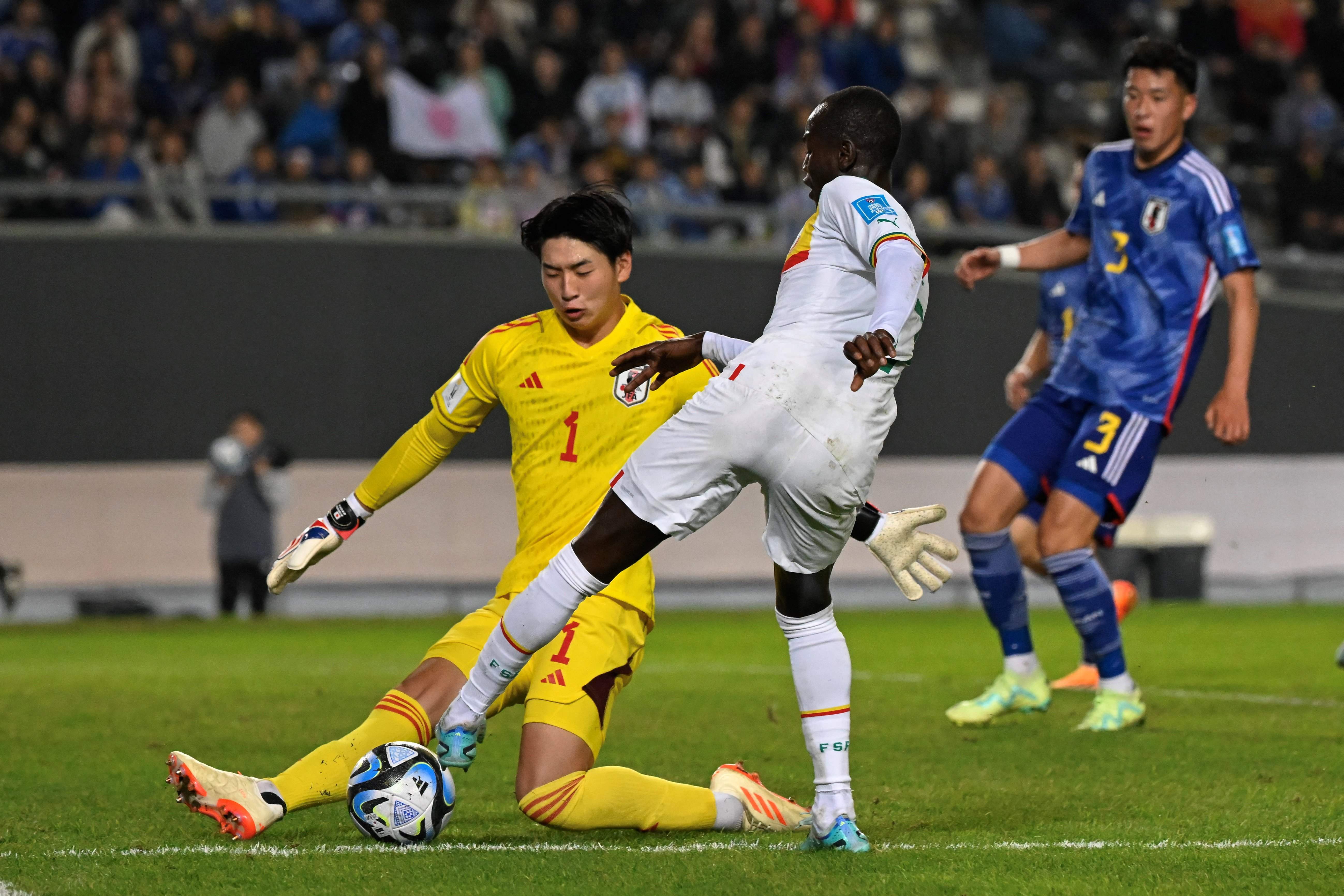 Kiper timnas U-20 Jepang Ryoya Kimura (kiri) menghentikan bola yang disepak oleh pemain Senegal Mame Mor Faye di Piala Dunia U-20 2023. 