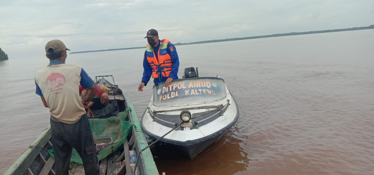 Seorang petugas Ditpolairud Polda Kalteng berdialog dengan seorang nelayan. 