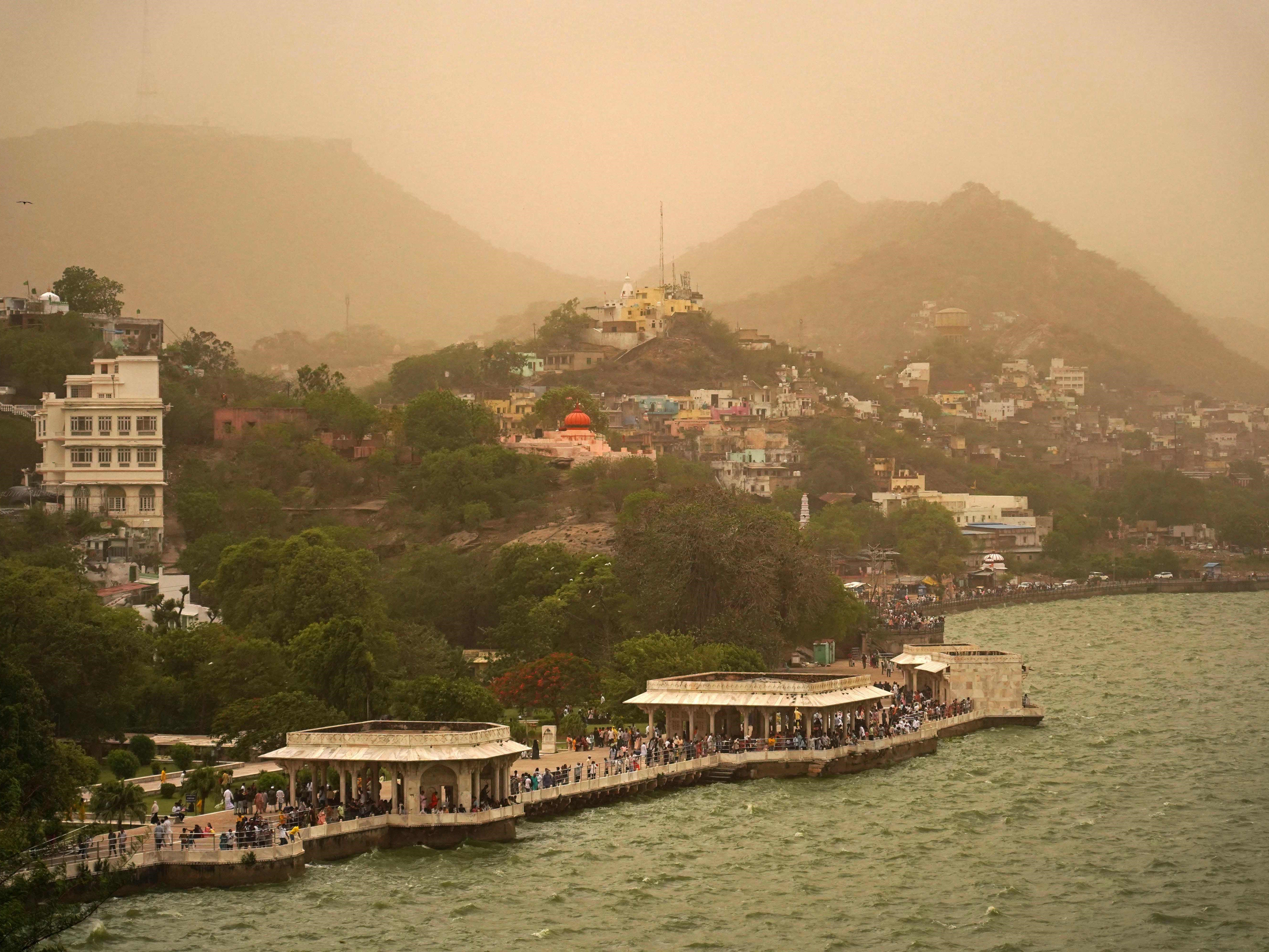 Turis berkumpul di sepanjang tepi Danau Anasagar saat terjadi badai debu di Ajmer, India, pada 28 Mei 2023. 