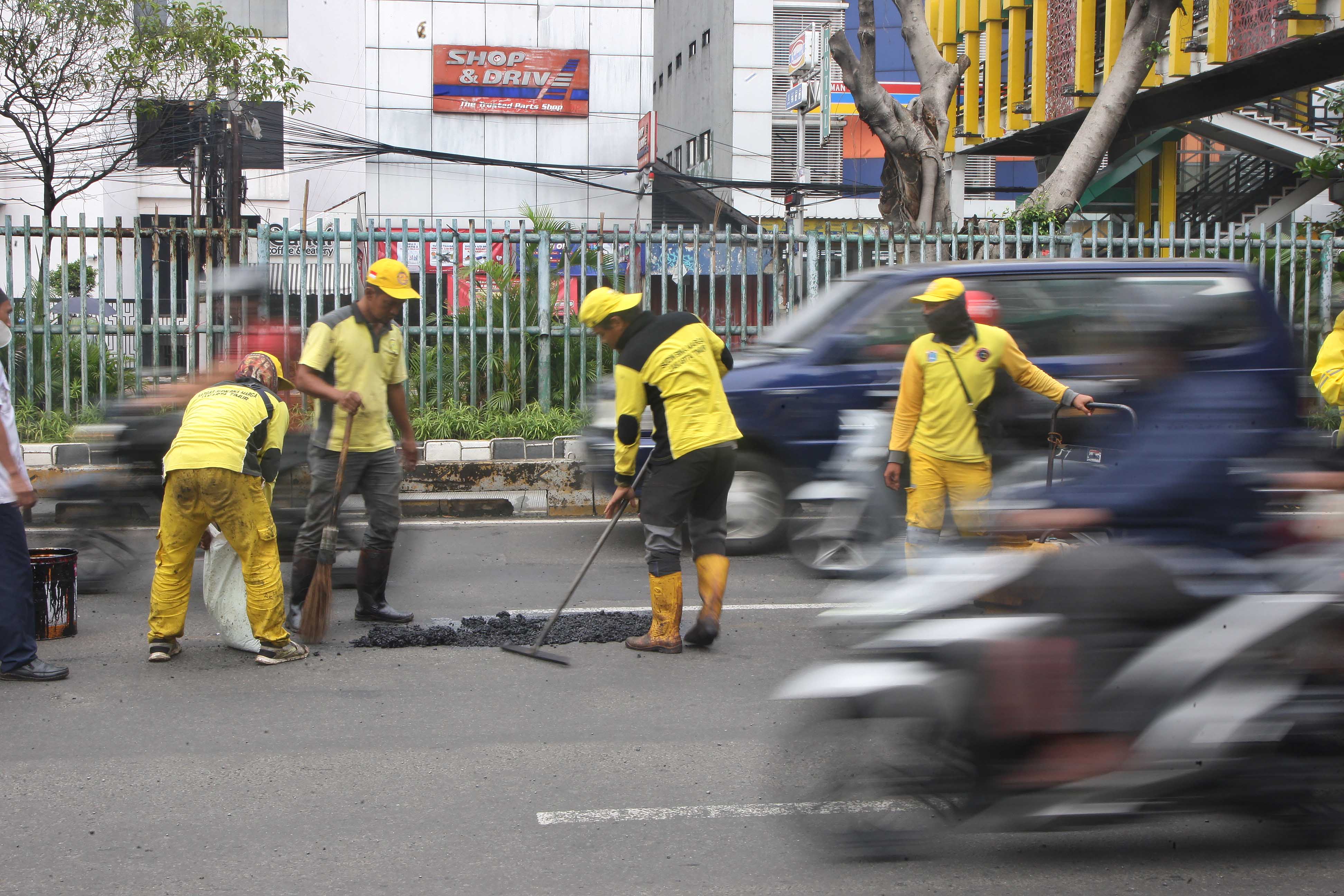 Petugas dari Suku Dinas Bina Marga DKI Jakarta memperbaiki jalan rusak di Jalan Matraman Raya, Jakarta, Timur, Rabu (15/03/2023)