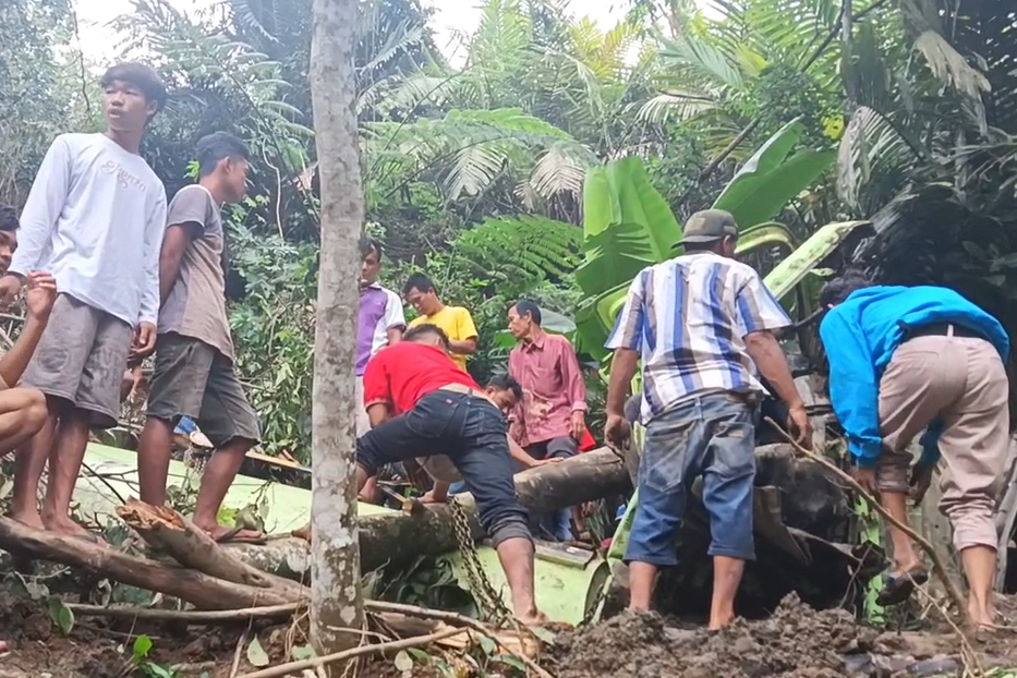 Warga mengevakuasi korban dari dalam truk.