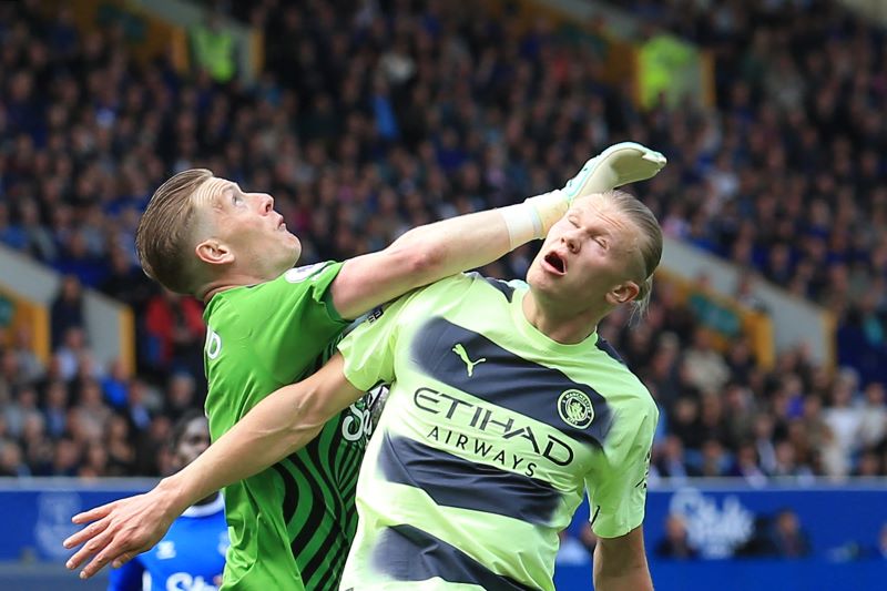 Kiper Everton Jordan Pickfor berduel udara dengan pemain Manchester City Erling Haaland.