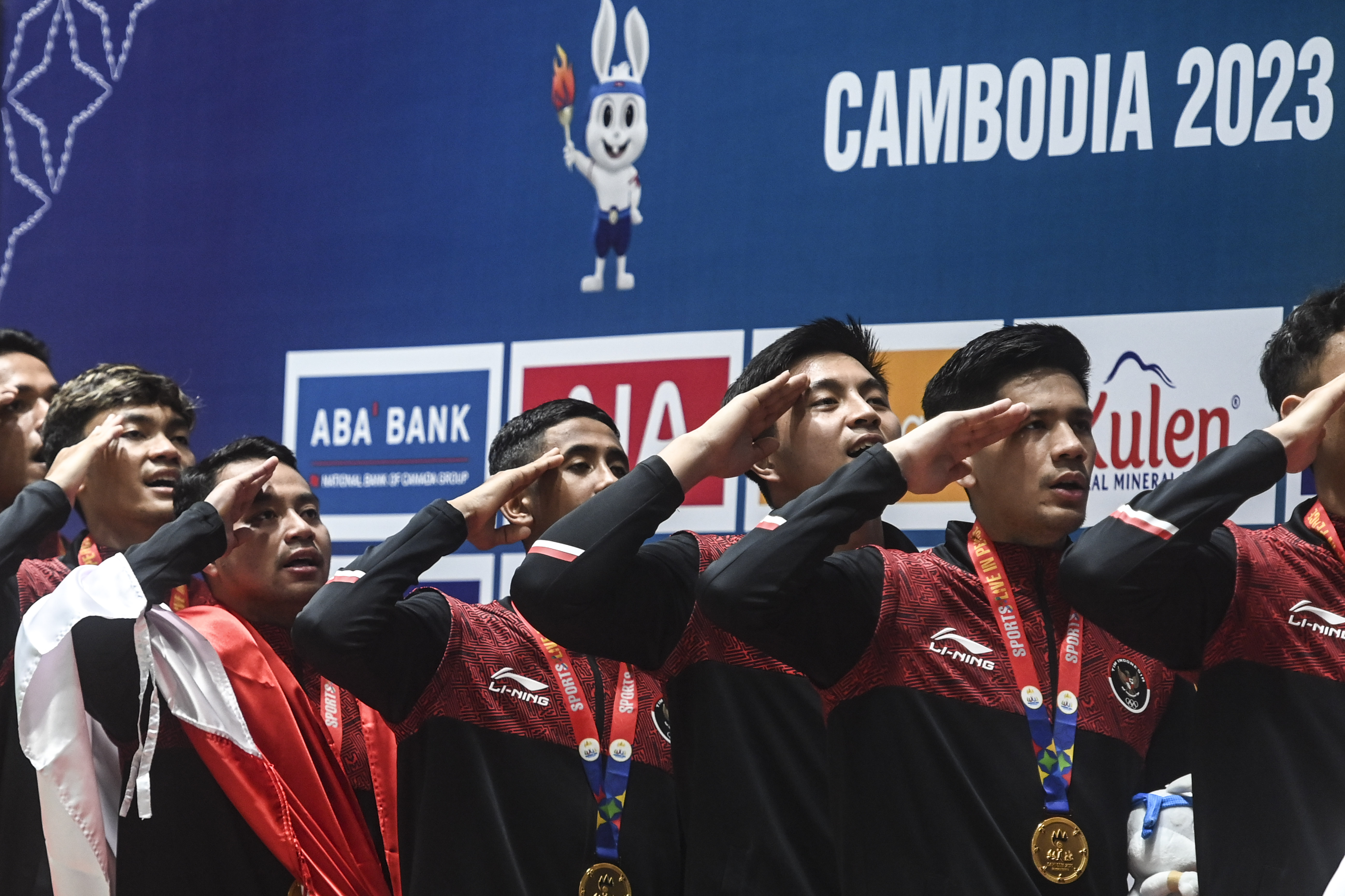 Tim bulu tangkis putra Indonesia memberi penghormatan ke bendera Merah Putih.