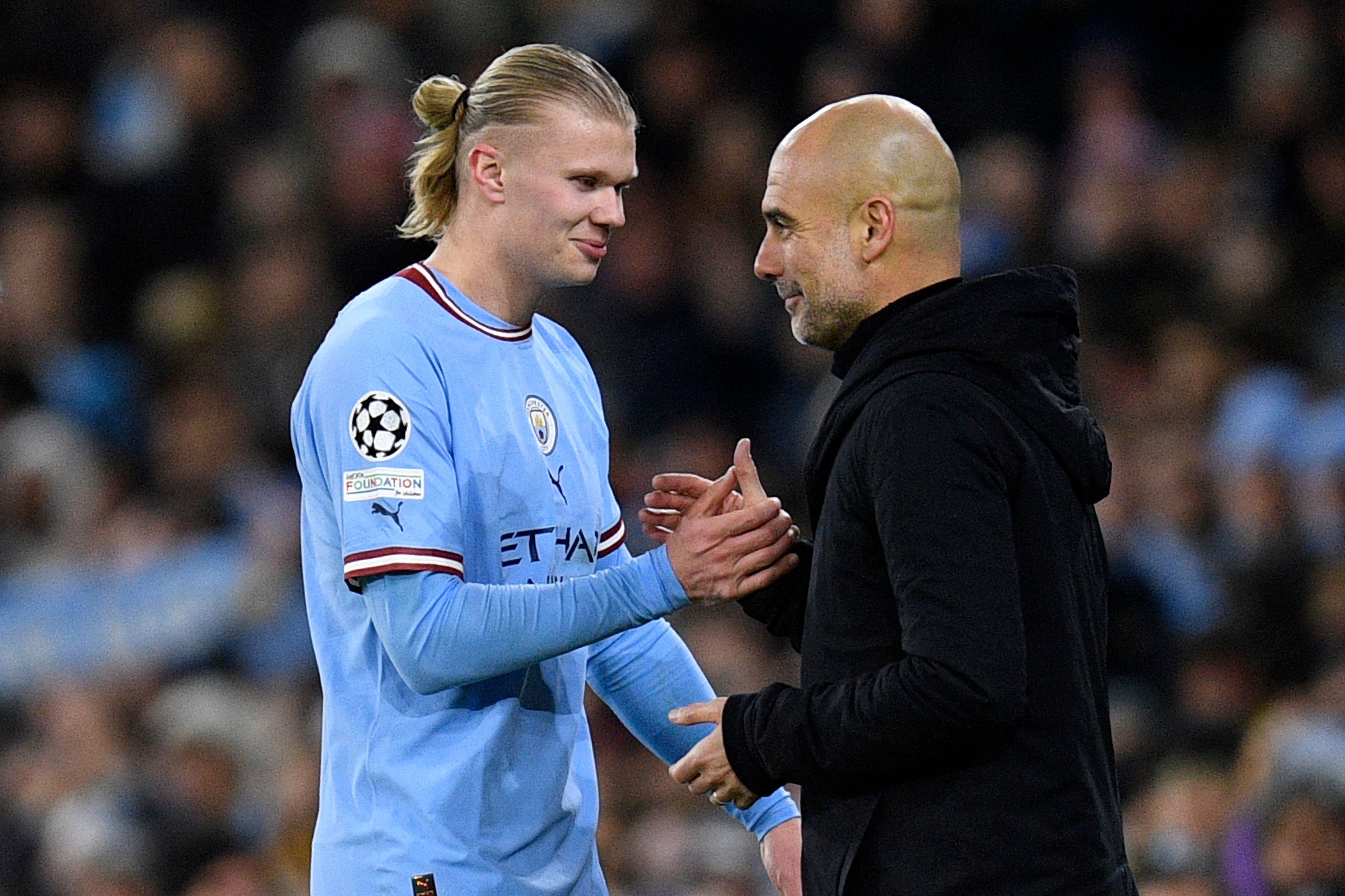 Penyerang Manchester City Erling Haaland (kiri) berjabat tangan dengan pelatih Pep Guardiola.