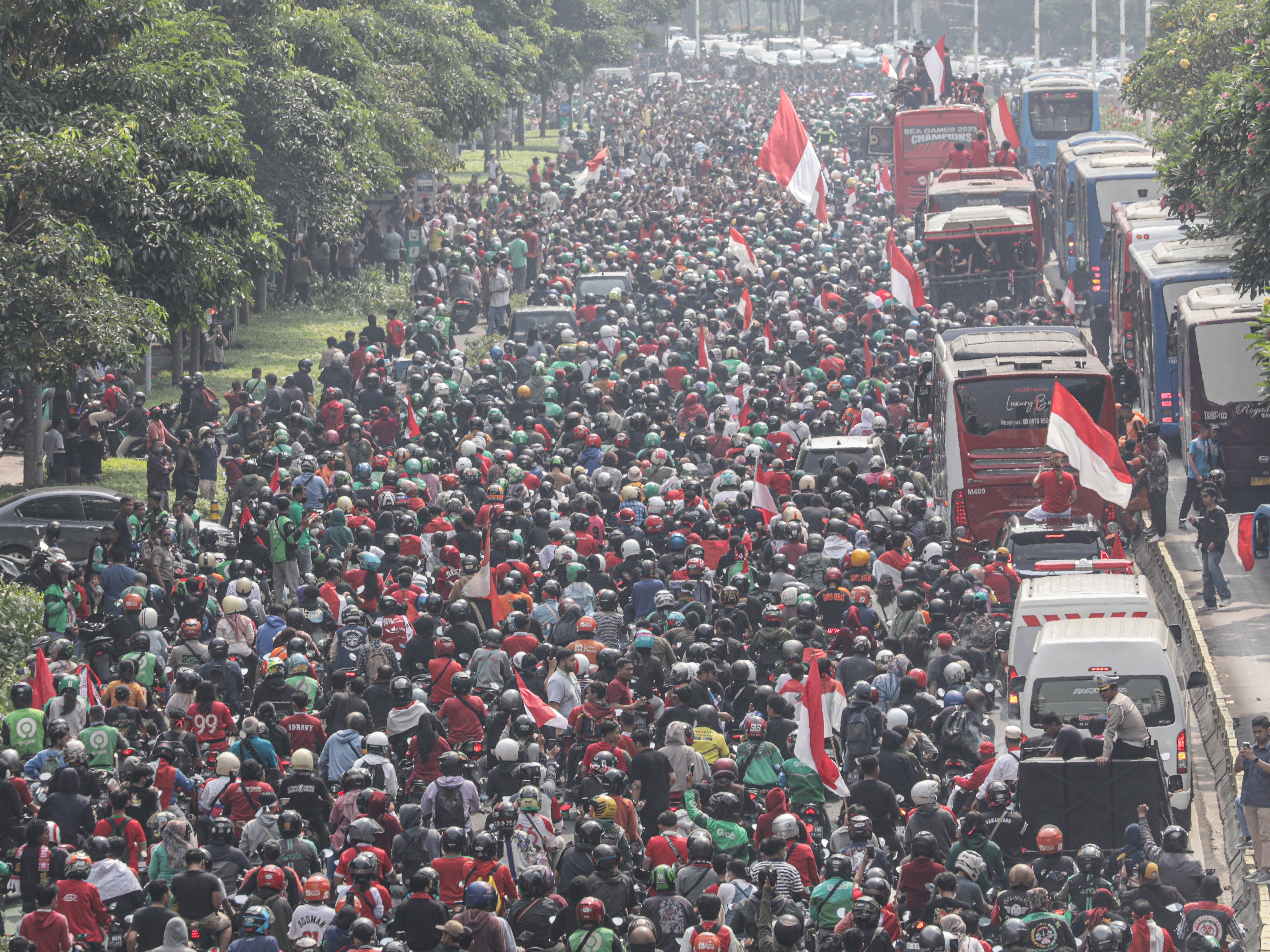 Pesepak bola Timnas Indonesia U-22 bersama ofisial dan pengurus PSSI berada di atas bus dalam arak-arakan Kira87uara Kontingen SEA Games.