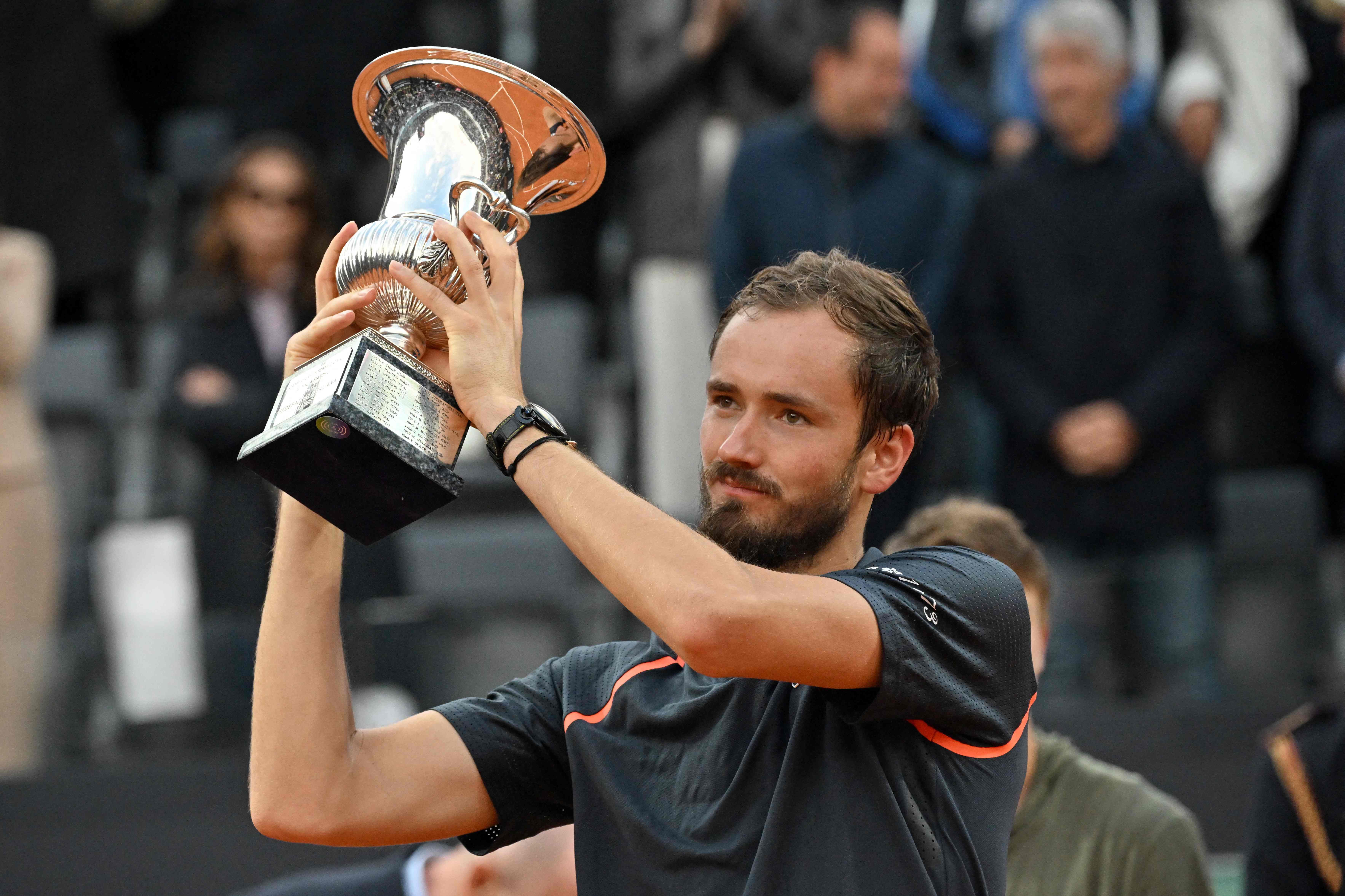 Daniil Medvedev mengangkat trofi usai menjadi juara turnamen tenis Italia Terbuka 2023, Minggu (21/5)