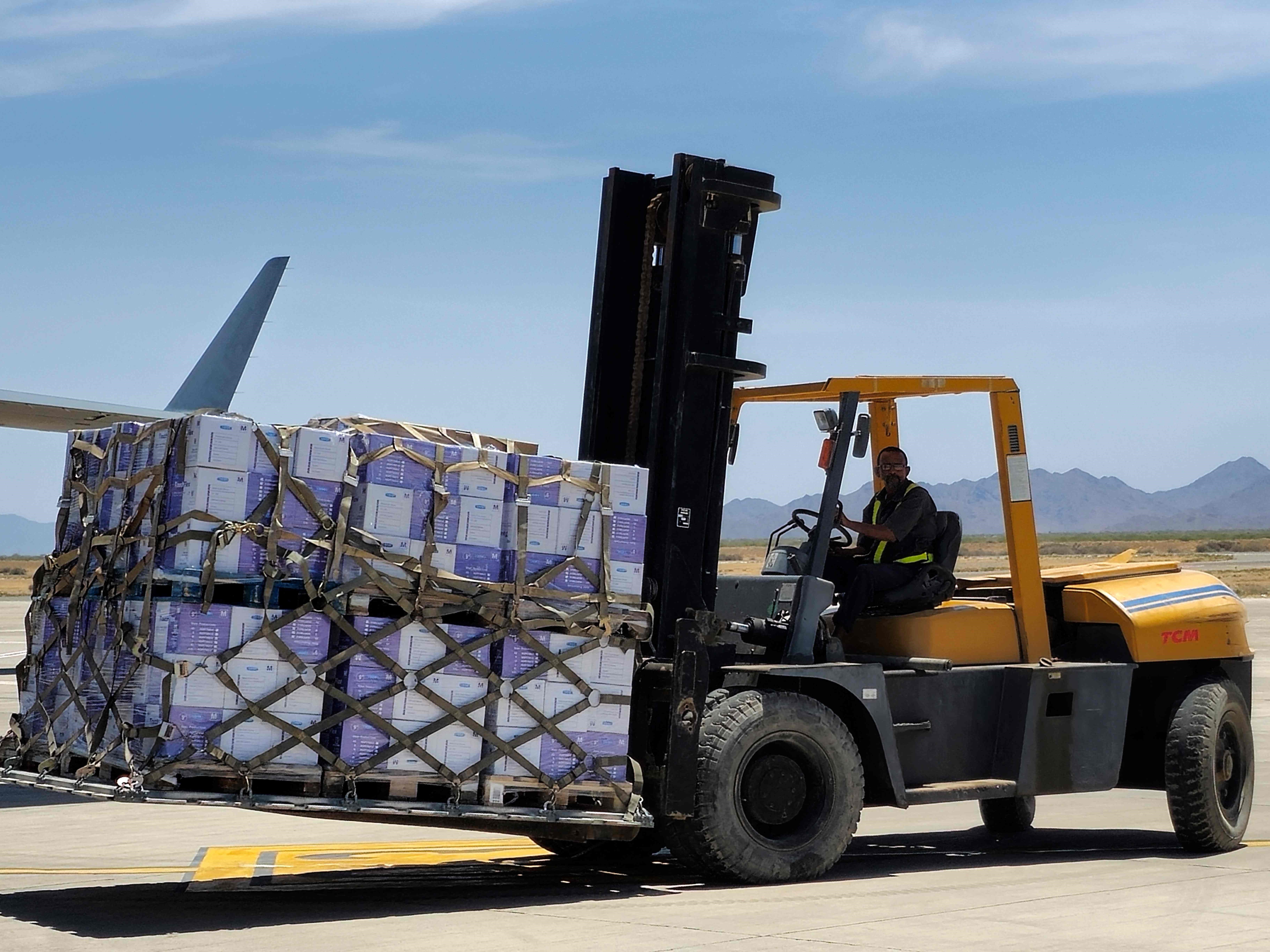 Seorang pekerja mengangkut persediaan bantuan saat pesawat Emirat mendarat di bandara Port Sudan pada 10 Mei 2023.