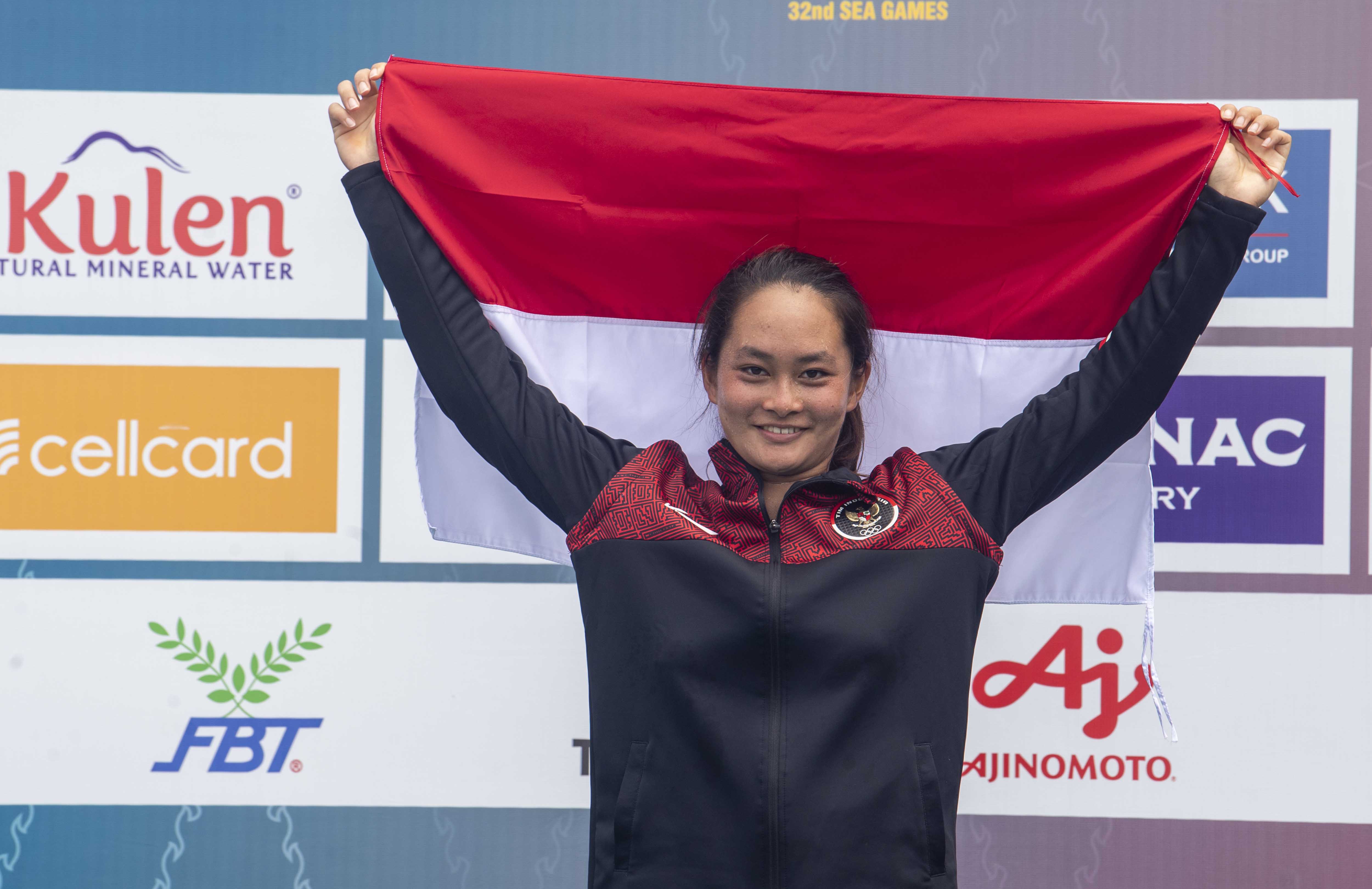 Petenis Indonesia Priska Madelyn Nugroho mengangkat bendera Merah Putih saat upacara penyerahan medali tunggal putri SEA Games 2023.