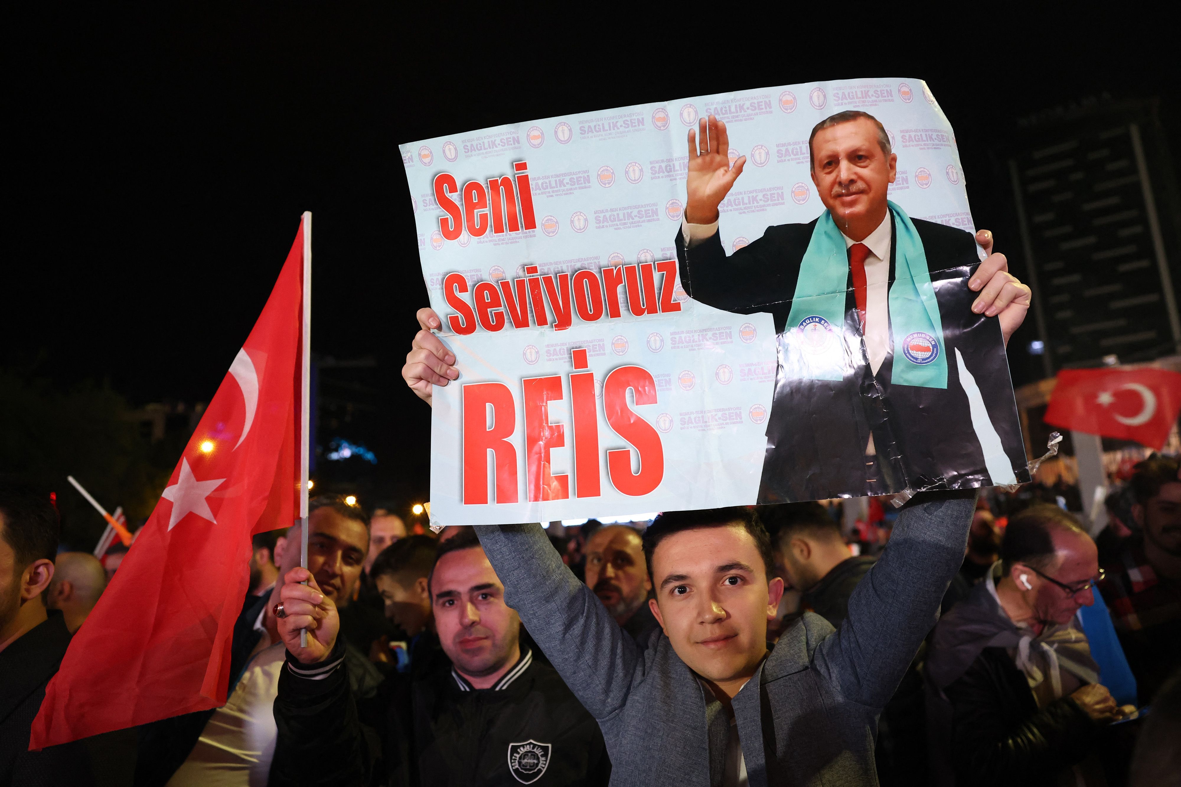 Pendukung Presiden Turki Tayyip Erdogan memegang poster bertuliskan 'We Love You Chief', 15 Mei 2023.