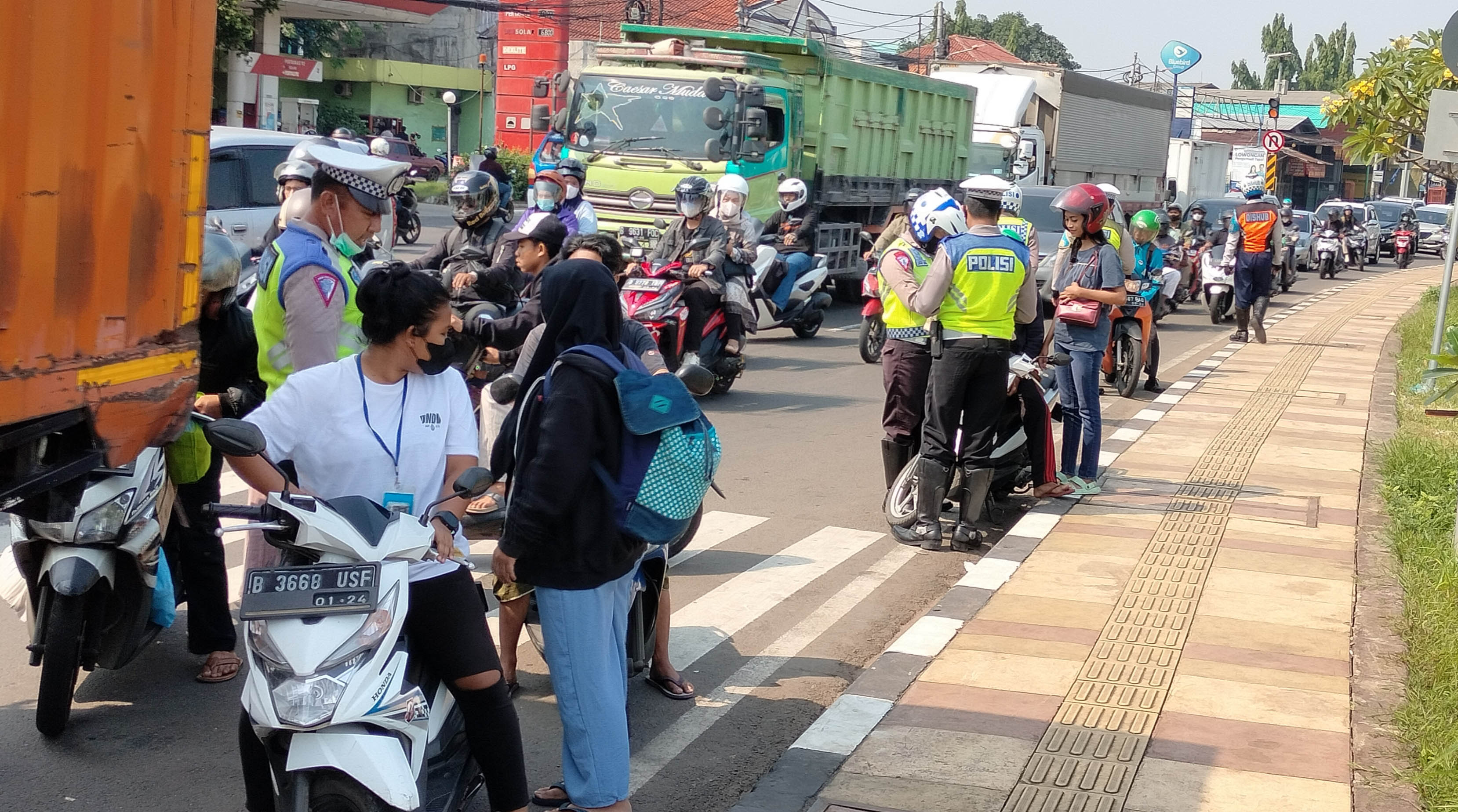 Polisi dan DLLAJR melakukan pemeriksaan kelengkapan surat-surat saat melakukan razia di Jalan Raya Bogor,Jakarta Timur. 