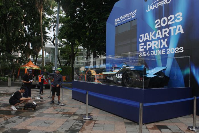 Masyarakat melakukan aktifitas menyaksikan dan berfoto di depan Replika Mobil Formula E saat car free day (CFD) di kawasan Bunderan HI.