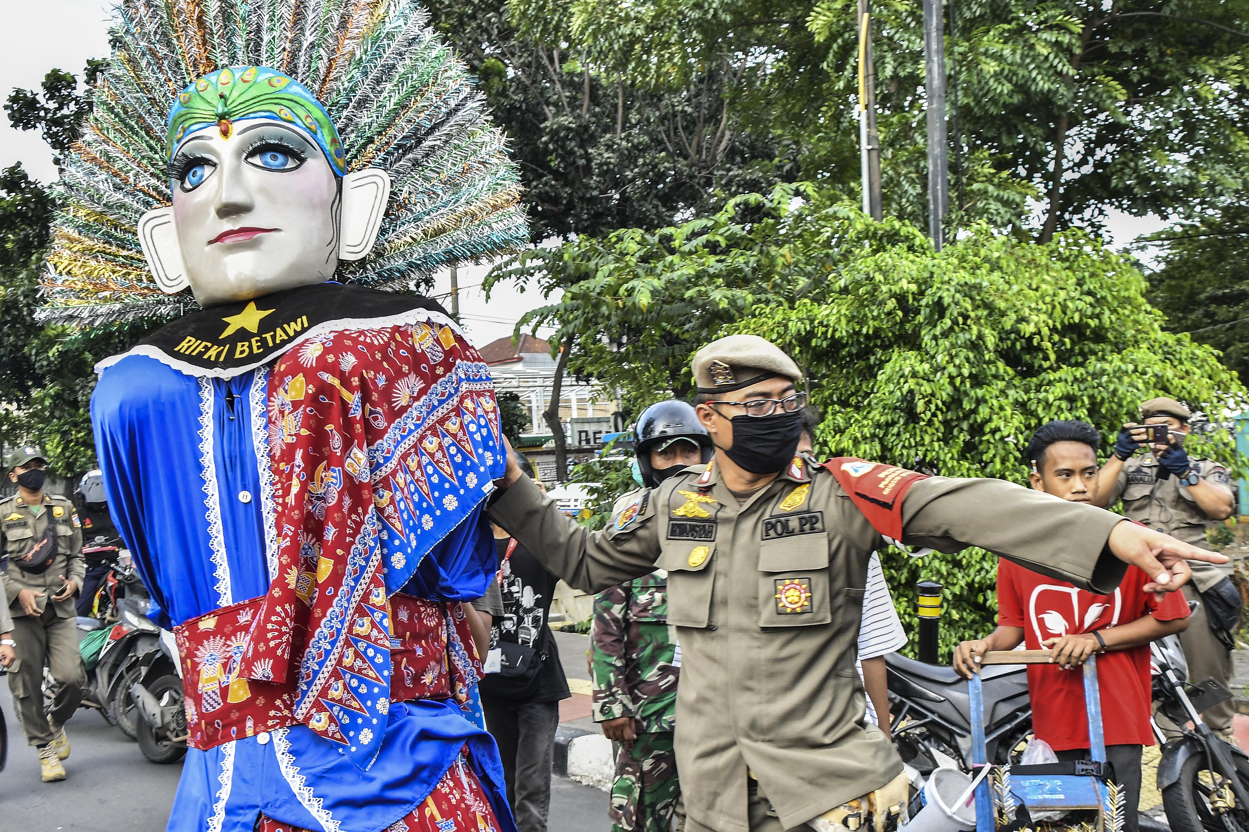 Sejumlah petugas gabungan dari TNI dan Satpol PP saat melakukan razia pengamen ondel-ondel di Jakarta Timur