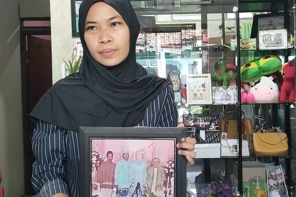 Anak korban, Linda, memperlihatkan foto ayahnya (kiri) yang menjadi korban meninggal dunia akibat kecelakaan bus di Tegal. 