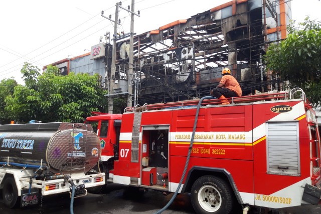 Petugas pemadam kebakaran memadamkan api di Mal Malang Plaza, Kota Malang, Jawa Timur, yang terbakar, Selasa (2/5). 