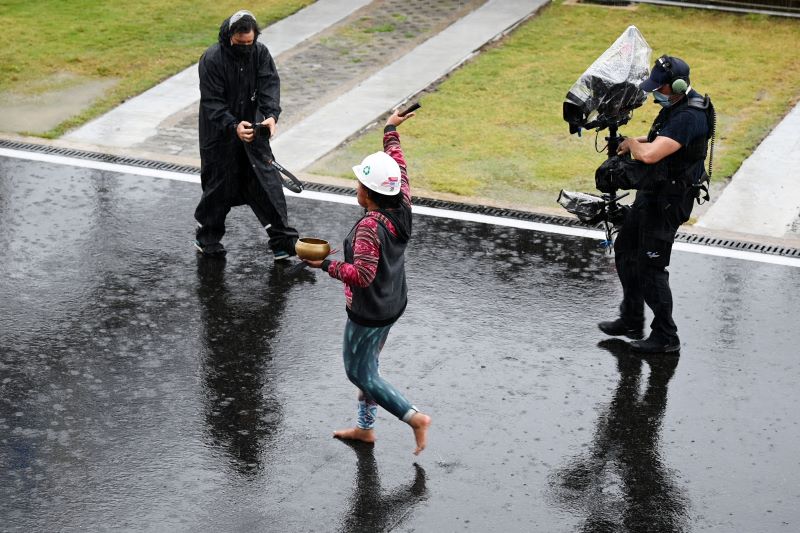 Pawang hujan Rara Isti Wulandari (tengah) melakukan ritual saat hujan mengguyur Pertamina Mandalika International Street Circuit.