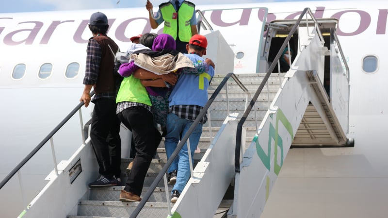 Ilustrasi: sejumlah petugas PPIH Embarkasi Solo membantu calon haji naik pesawat