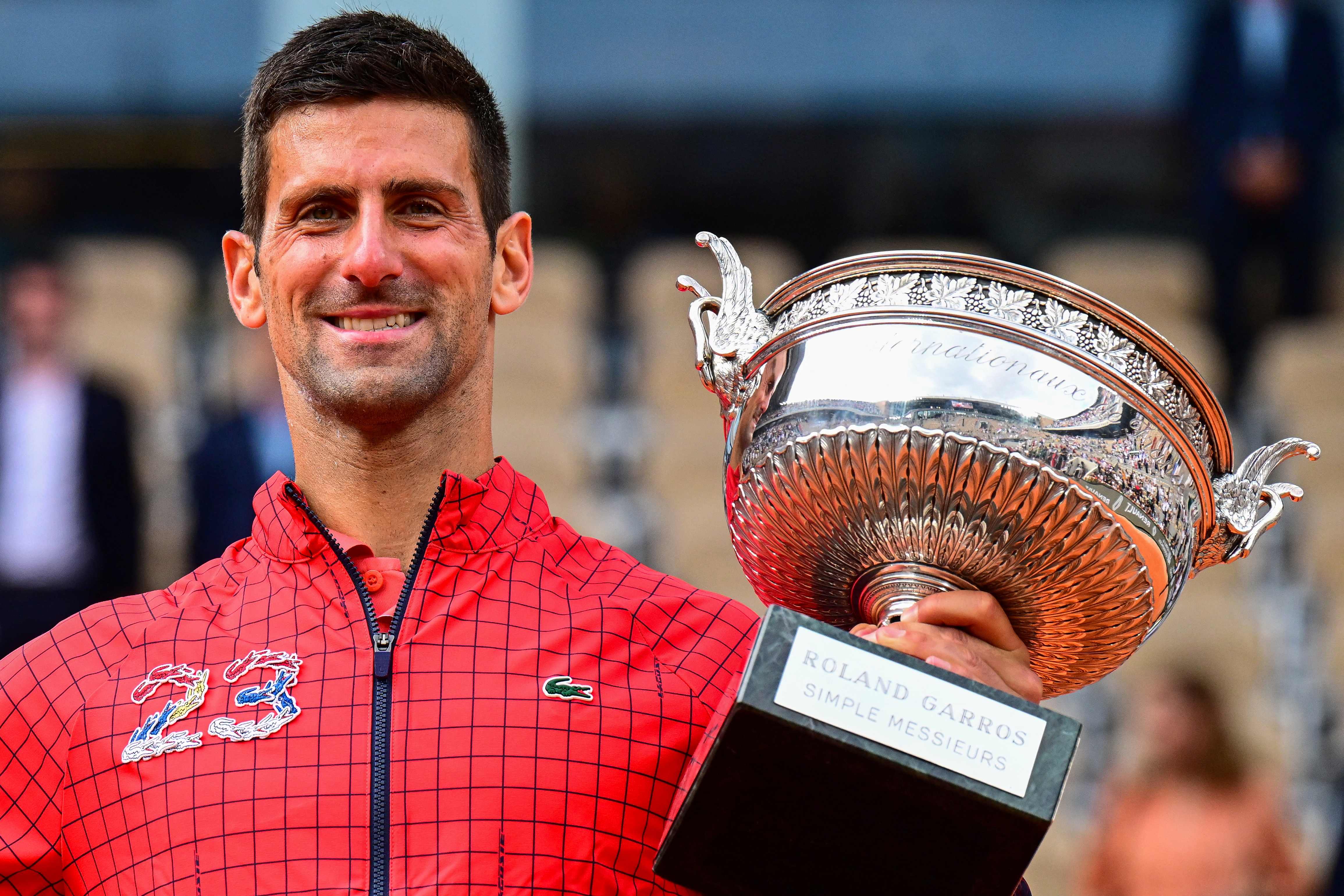 Petenis Serbia Novak Djokovic memamerkan trofi Prancis Terbuka yang dimenangkannya.