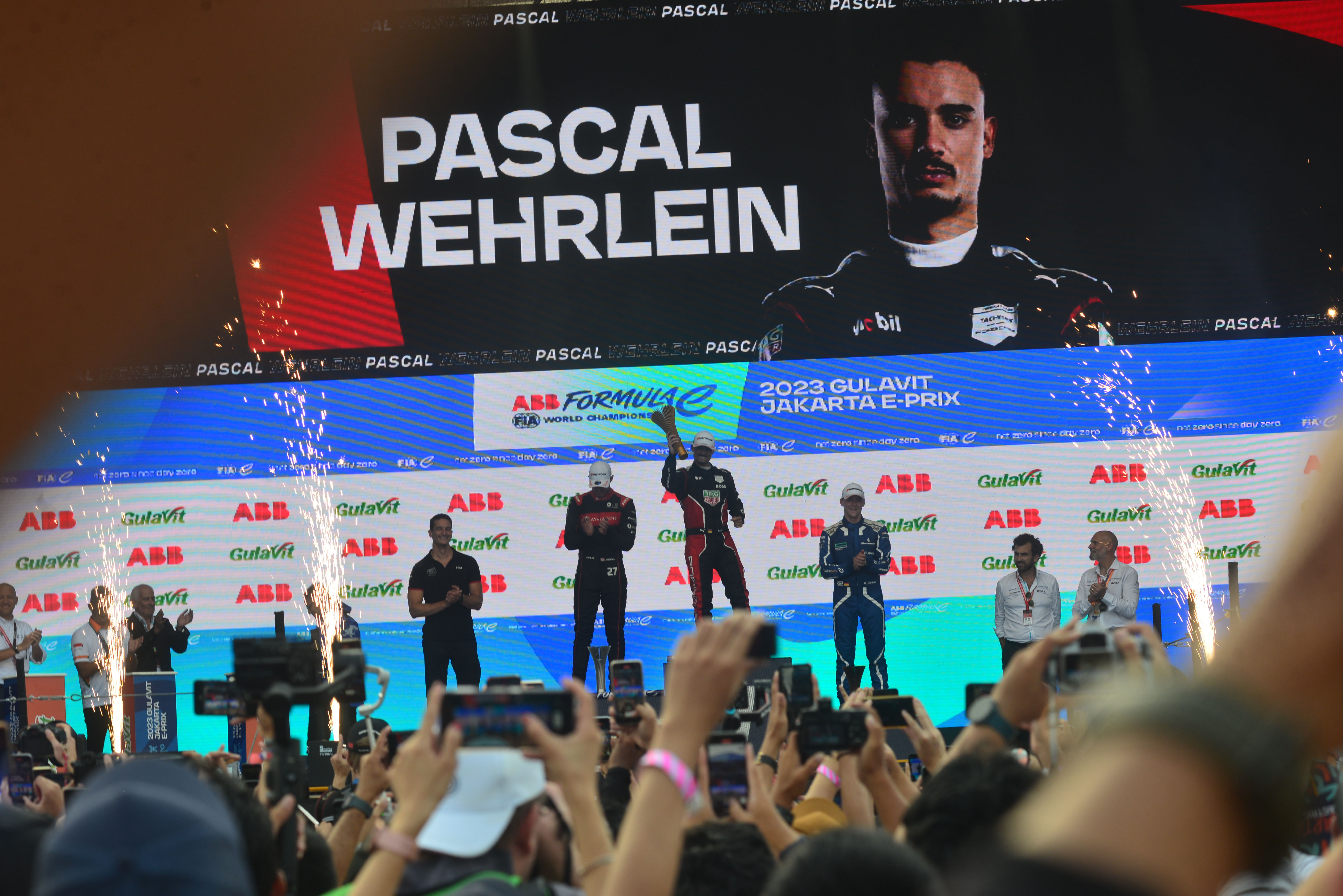 Pembalap Tag Heuer Pascal Wehrlein (tengah) mengangkat trofi usai memenangi balapan Formula E di Jakarta, Sabtu (3/6).
