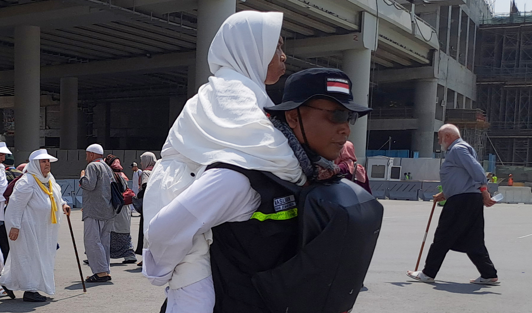 Petugas menggendong jamaah calon haji lansia