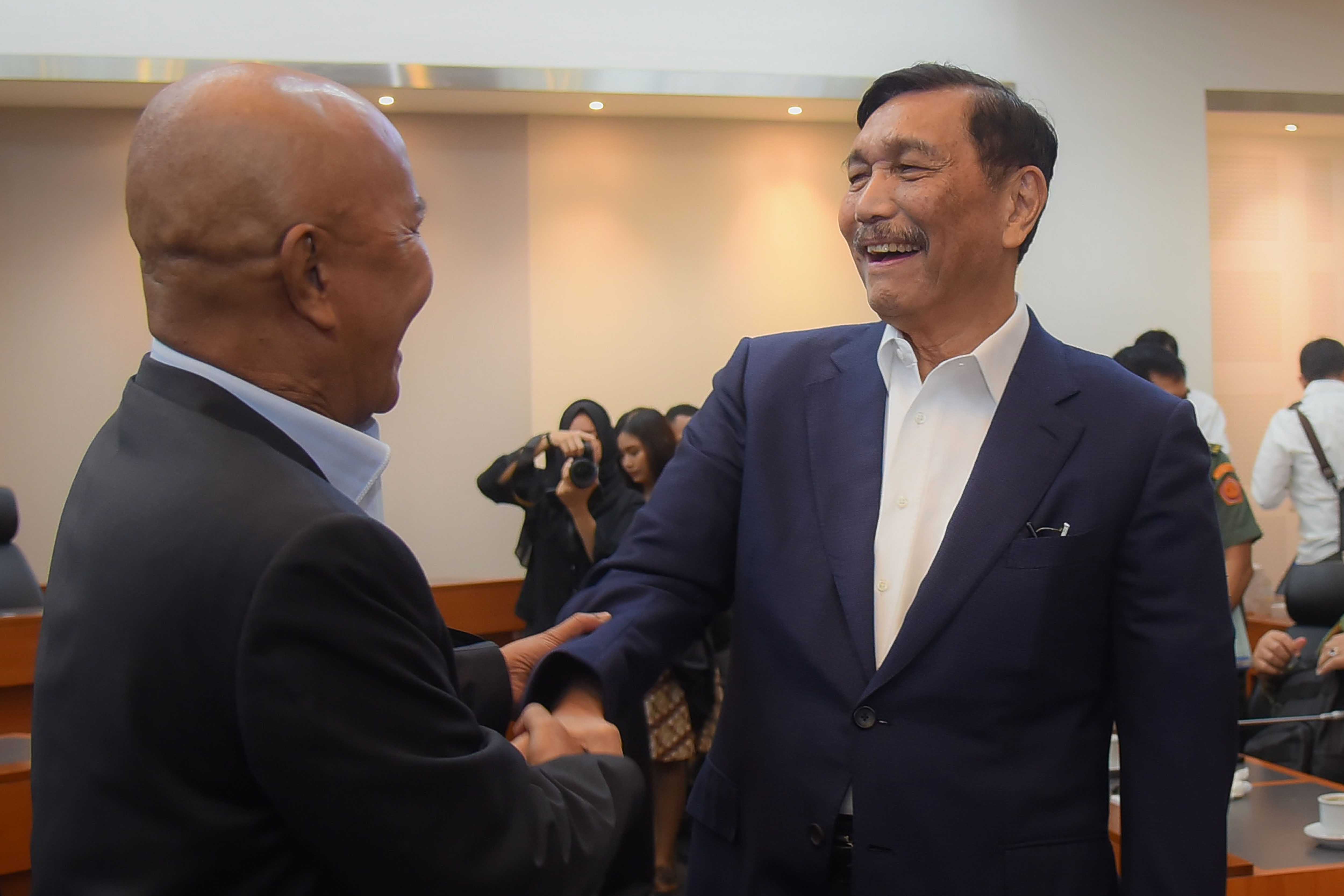 Menko Marves Luhut Binsar Pandjaitan (kanan) berjabat tangan dengan Ketua Banggar DPR Said Abdullah usai rapa kerja di kompleks Parlemen