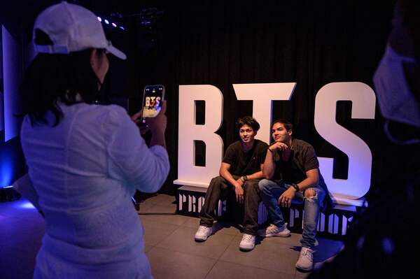 Fans berfoto di depan pop-up BTS.