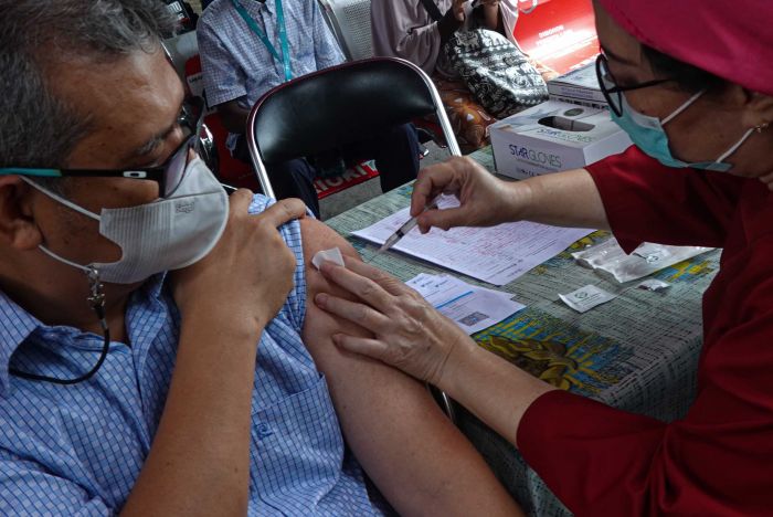 Petugas kesehatan menyuntikkan vaksin covid-19 booster kedua kepada seorang warga di Puskemas Jati Padang, Jakarta. 