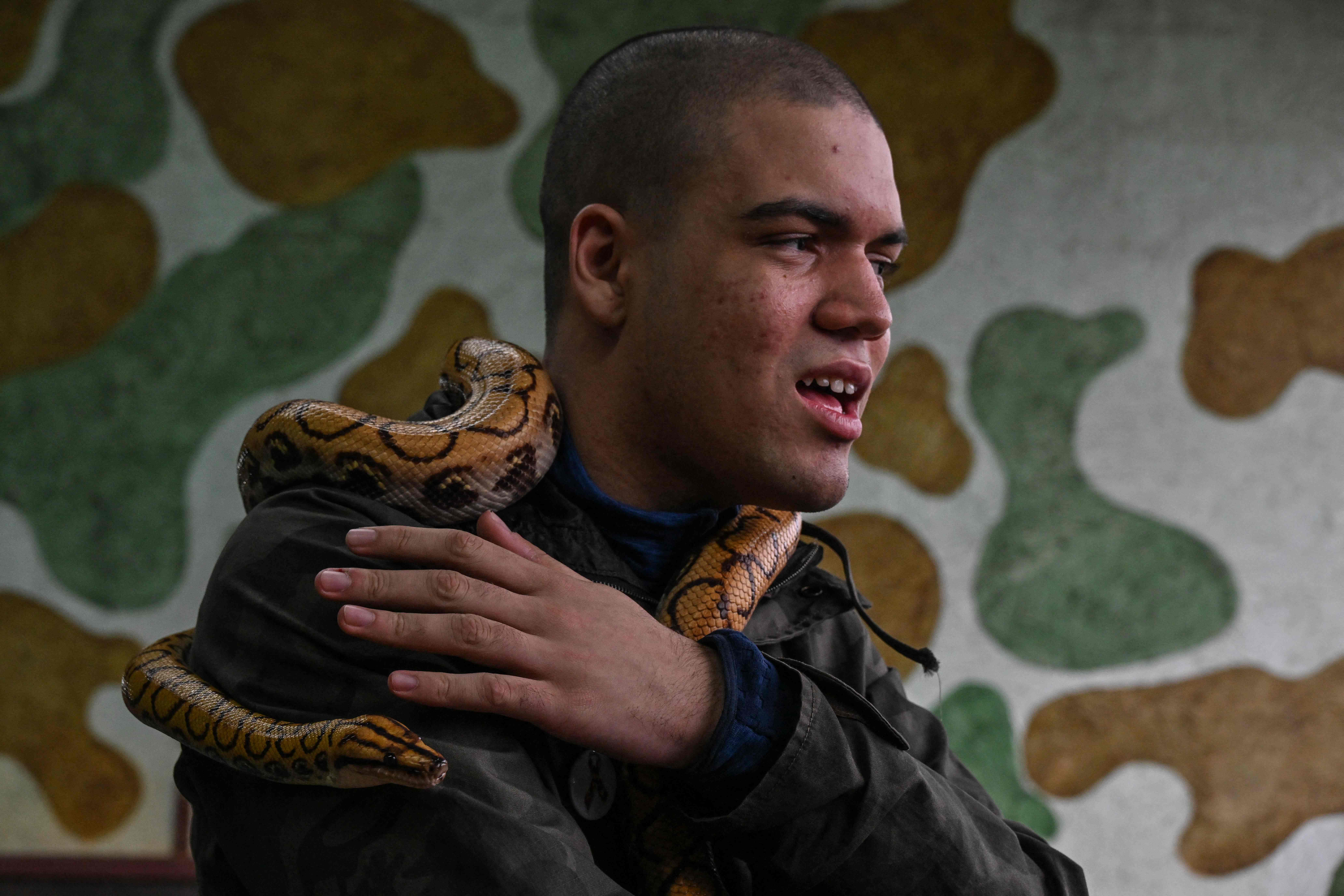 David de Oliveira Gomes, 15, pengidap autisme sedang menjalani sesi terapi ular di Brasil.