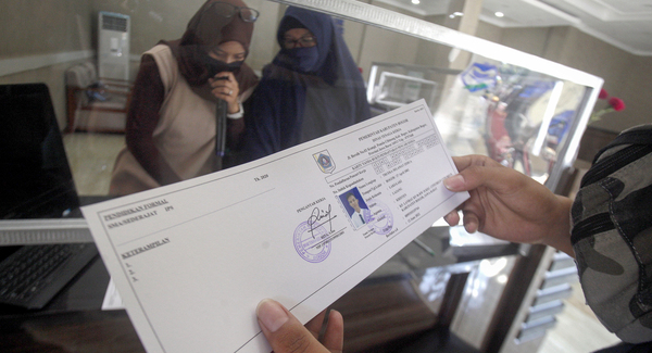 Pencari kerja mengambil Kartu Kuning (AK1) yang baru selesai dibuat di Kantor Dinas Tenaga Kerja Kabupaten Bogor.