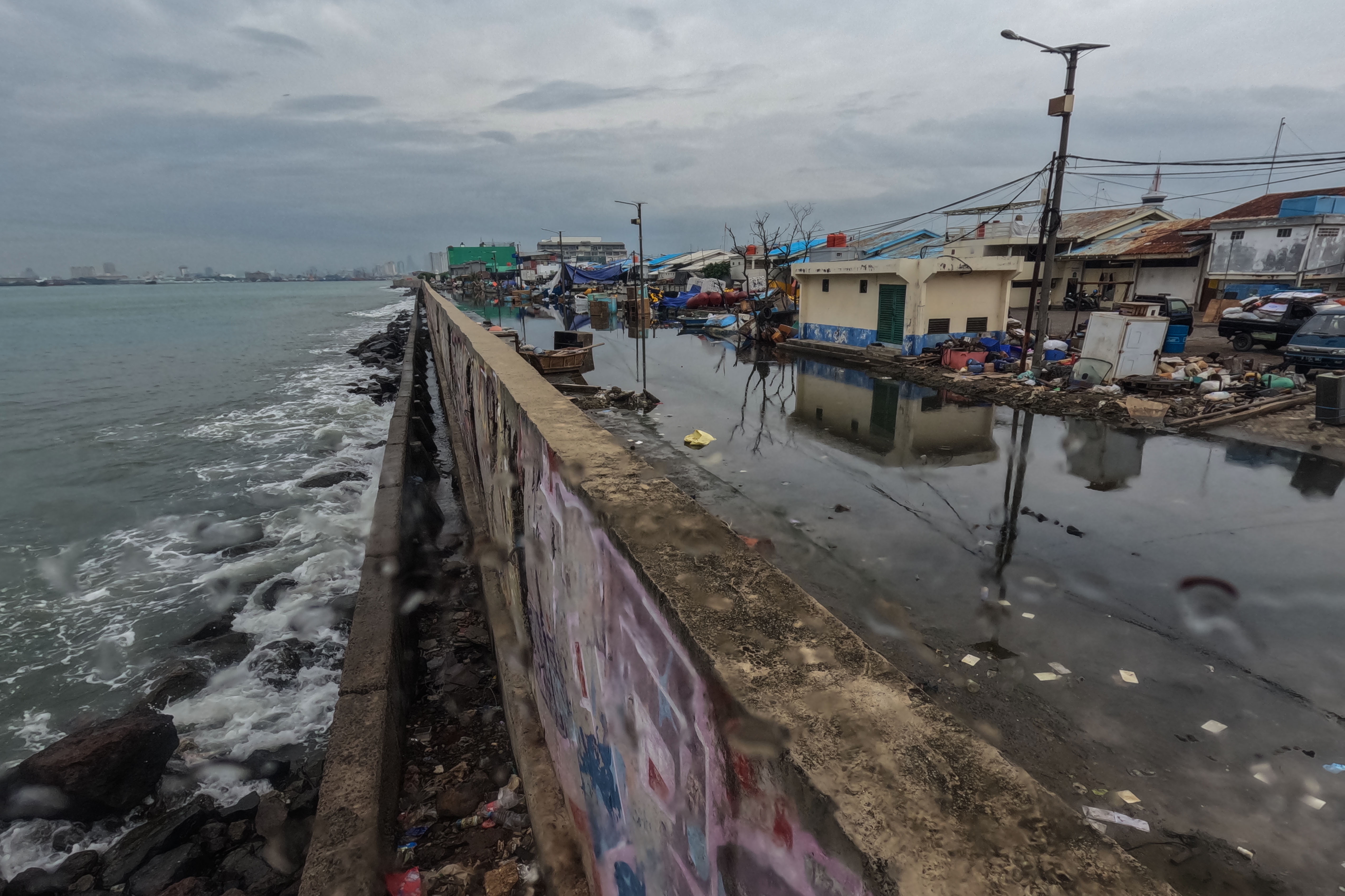 Suasana jalan yang terendam limpasan air laut ke daratan atau rob di Pelabuhan Muara Baru Jakarta, Rabu (28/12/2022).