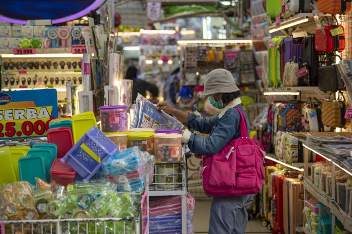 Warga berbelanja di salah satu toko di Pasar Baru, Jakarta.