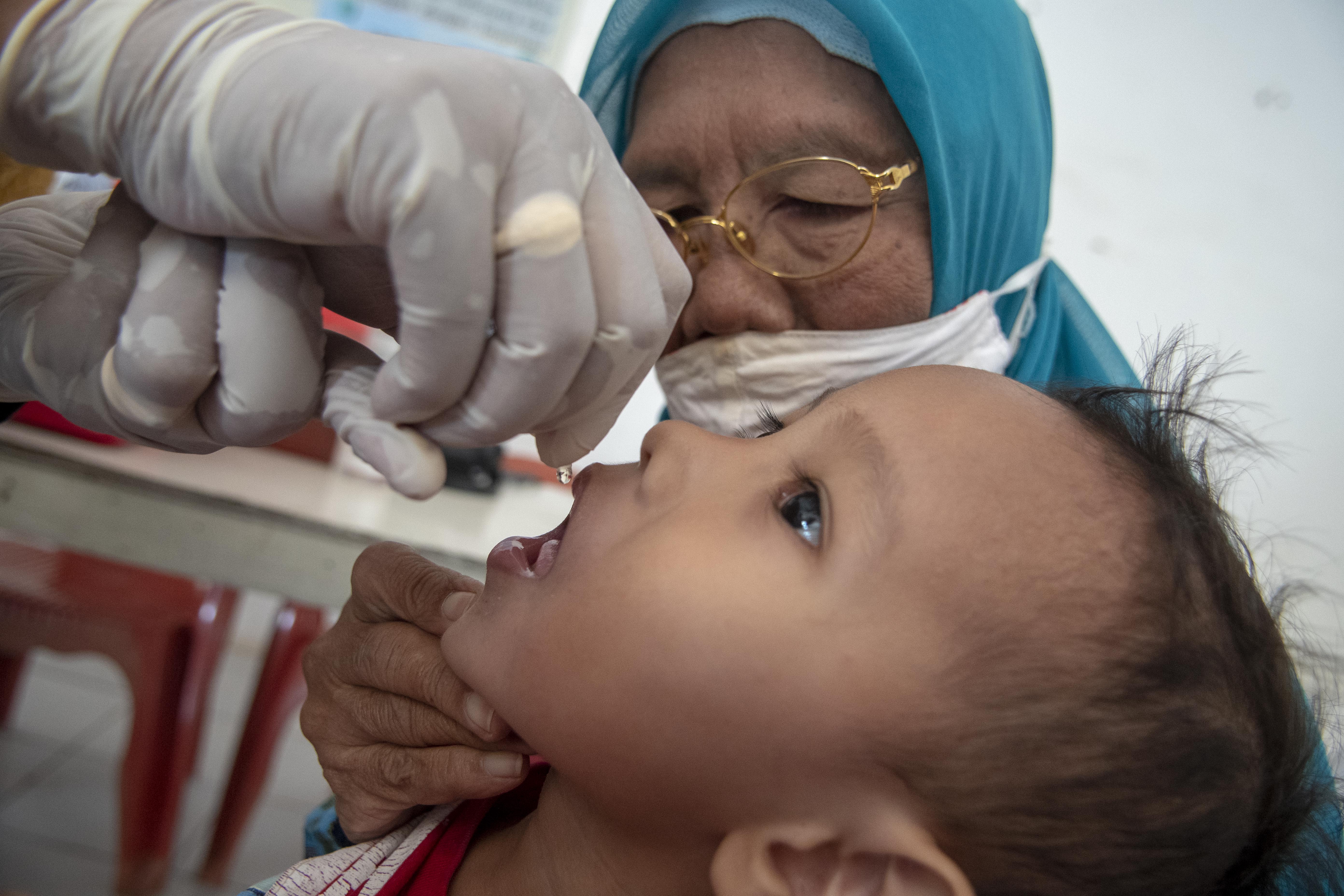 Nakes memberikan imunisasi polio kepada balita dalam Bulan Imuniasi Anak Nasional (BIAN) 2023 di Posyandu Cibinong, Bogor, Jawa Barat.