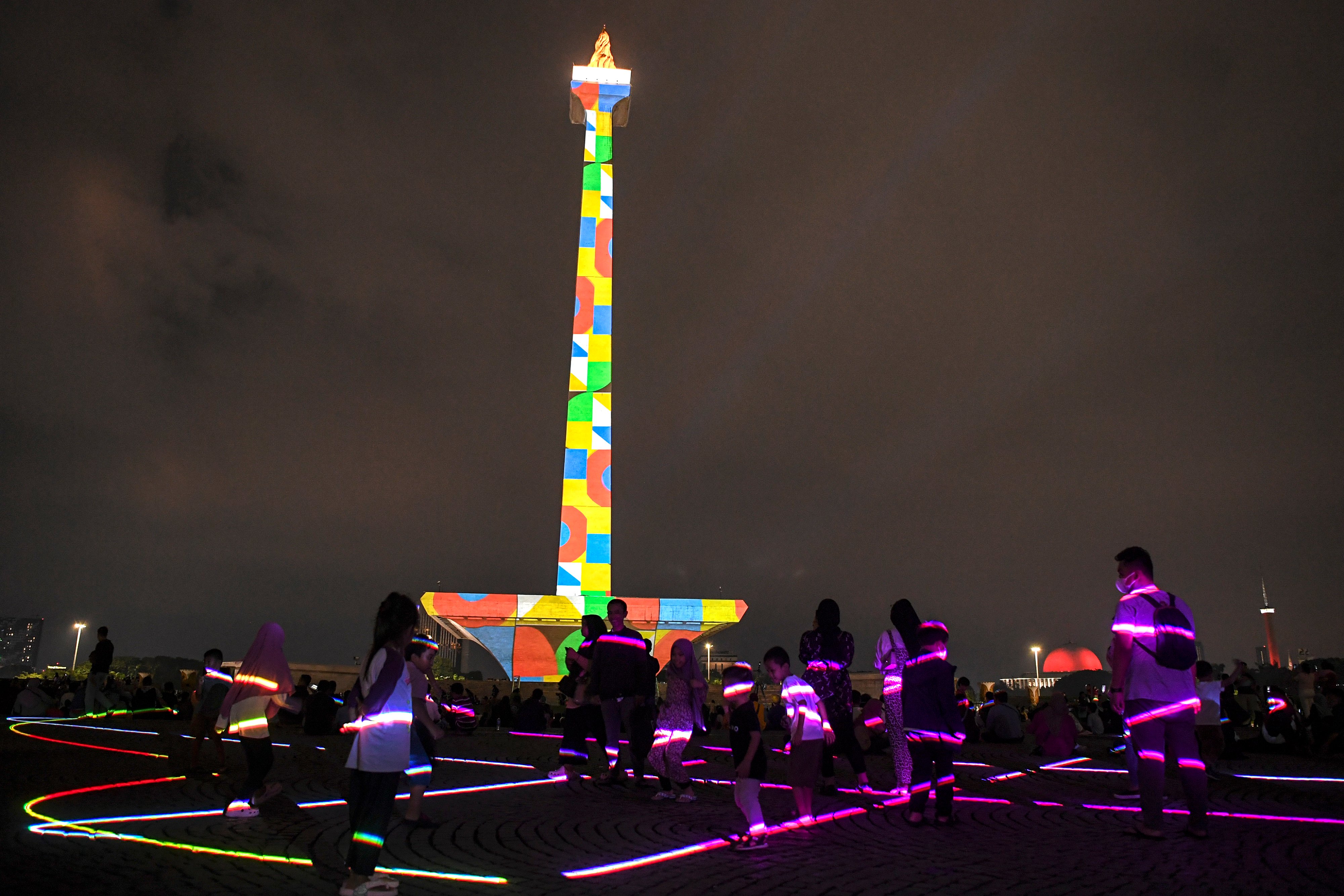 Pengunjung menyaksikan pertunjukan video mapping di Monumen Nasional (Monas), Jakarta, Senin (24/4).