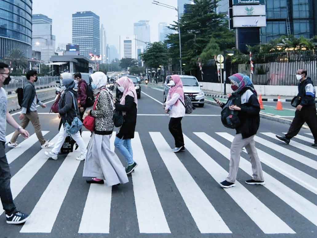 Pekerja menyebrang jalan di kawasan bisnis Jakarta