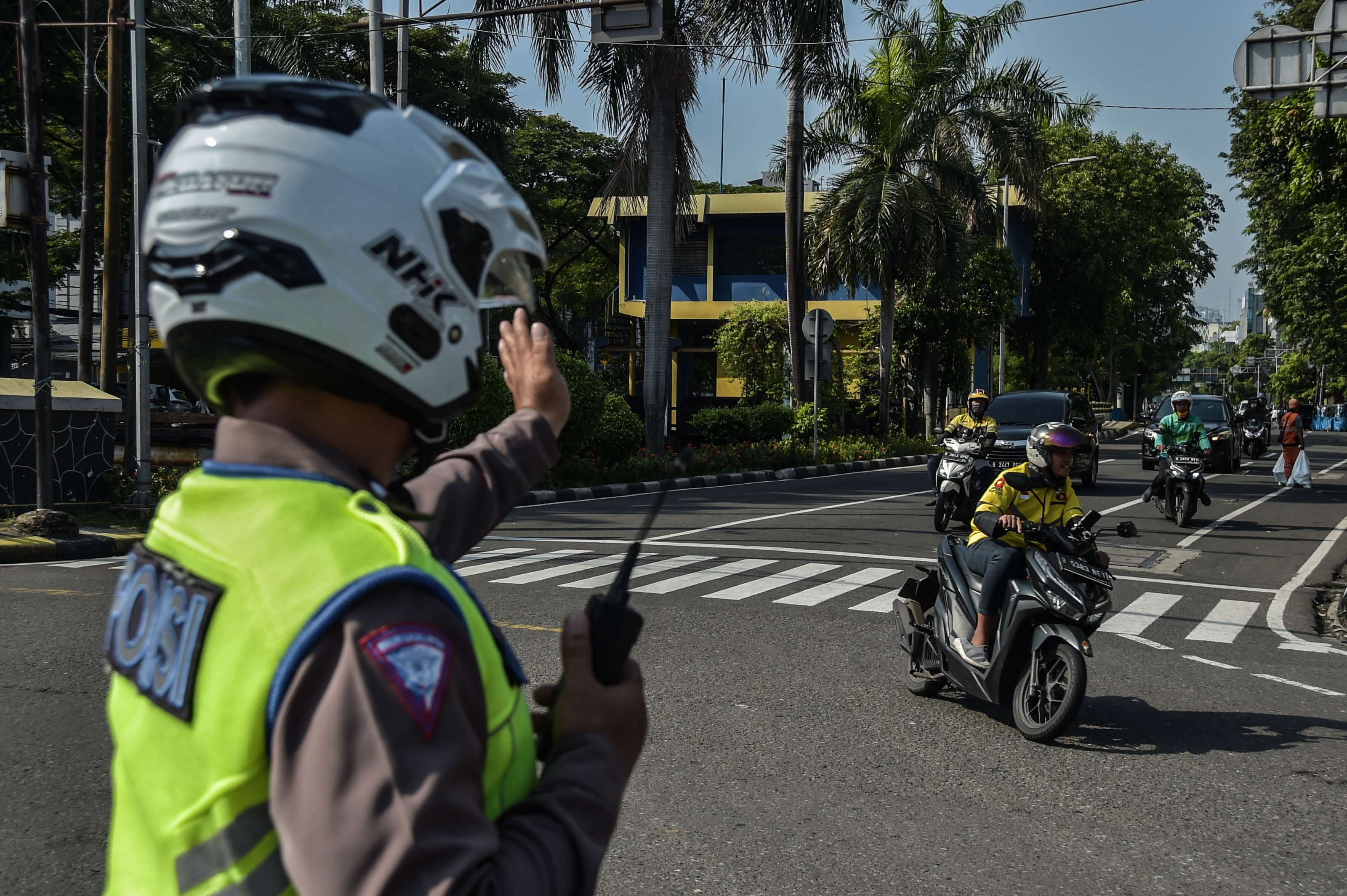 Petugas polisi mengatur arus lalu lintas.