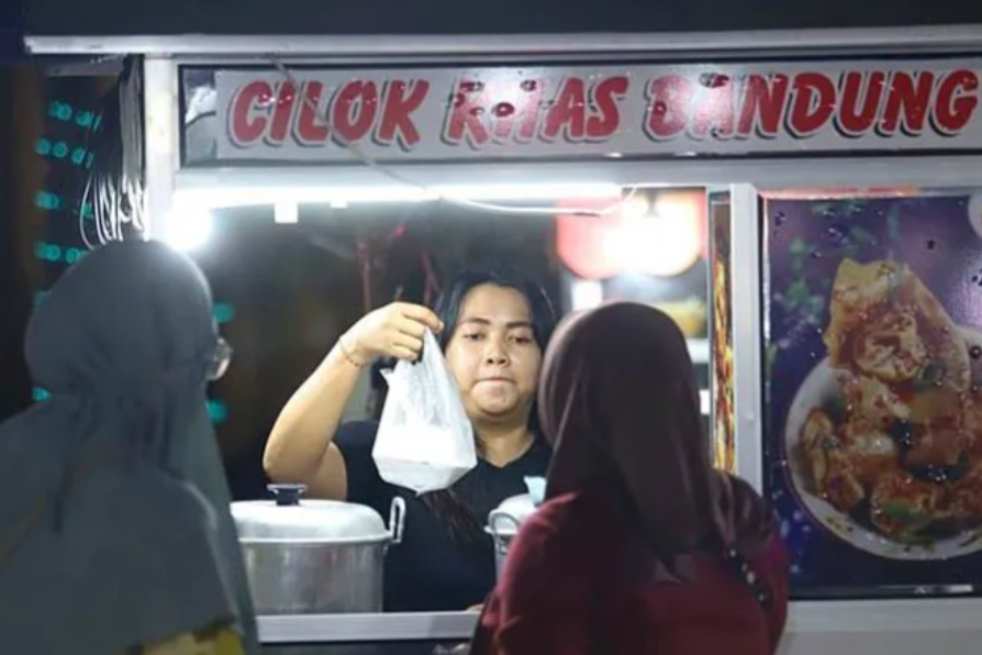 Pedagang melayani pembeli saat kegiatan nobar laga FIFA Matchday Timnas Indonesia melawan Argentina, Alun-alun Jember, Jatim, Senin (19/6).